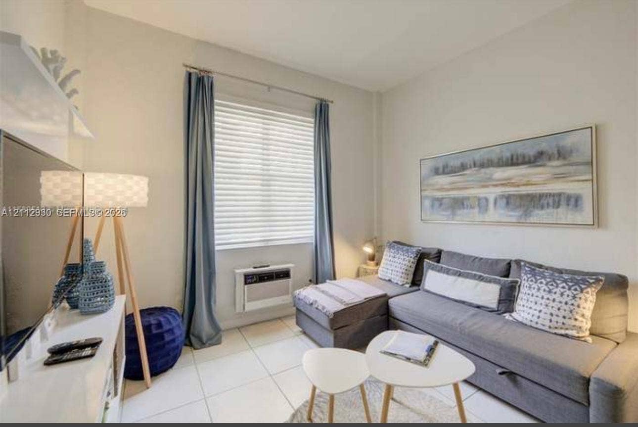 3030 Collins Avenue, #1G, Miami Beach, FL 33140 Neutral-toned walls paired with large-format light tile flooring and a wall-mounted climate control unit