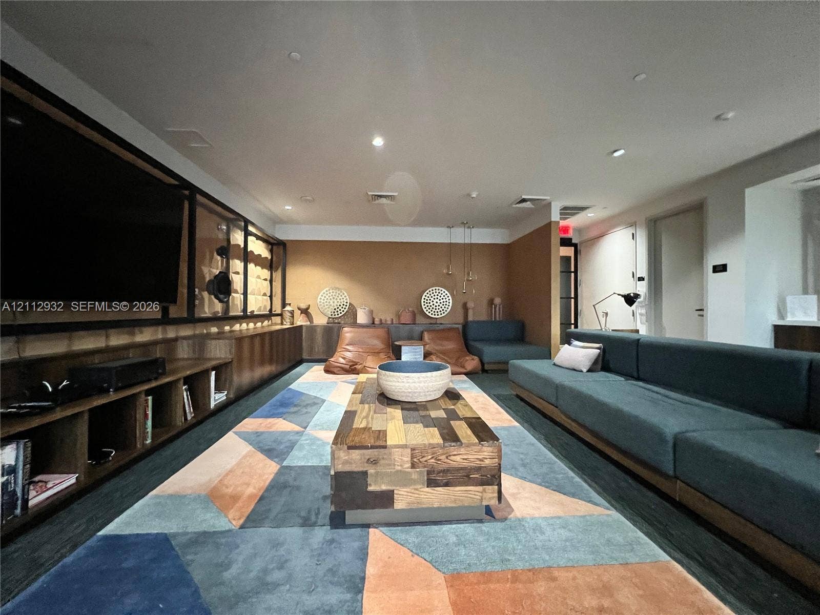 121 NE 34th Street, #903, Miami, FL 33137 Custom wood cabinetry featuring integrated open shelving, recessed ceiling lighting, and solid surface paneling