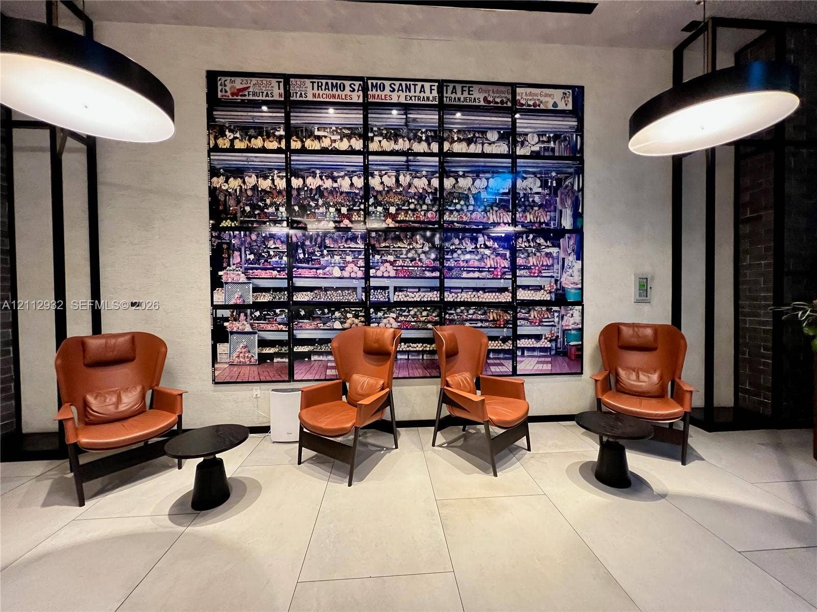121 NE 34th Street, #903, Miami, FL 33137 Large-format decorative wall installation, oversized circular pendant lighting, and light-toned tile flooring