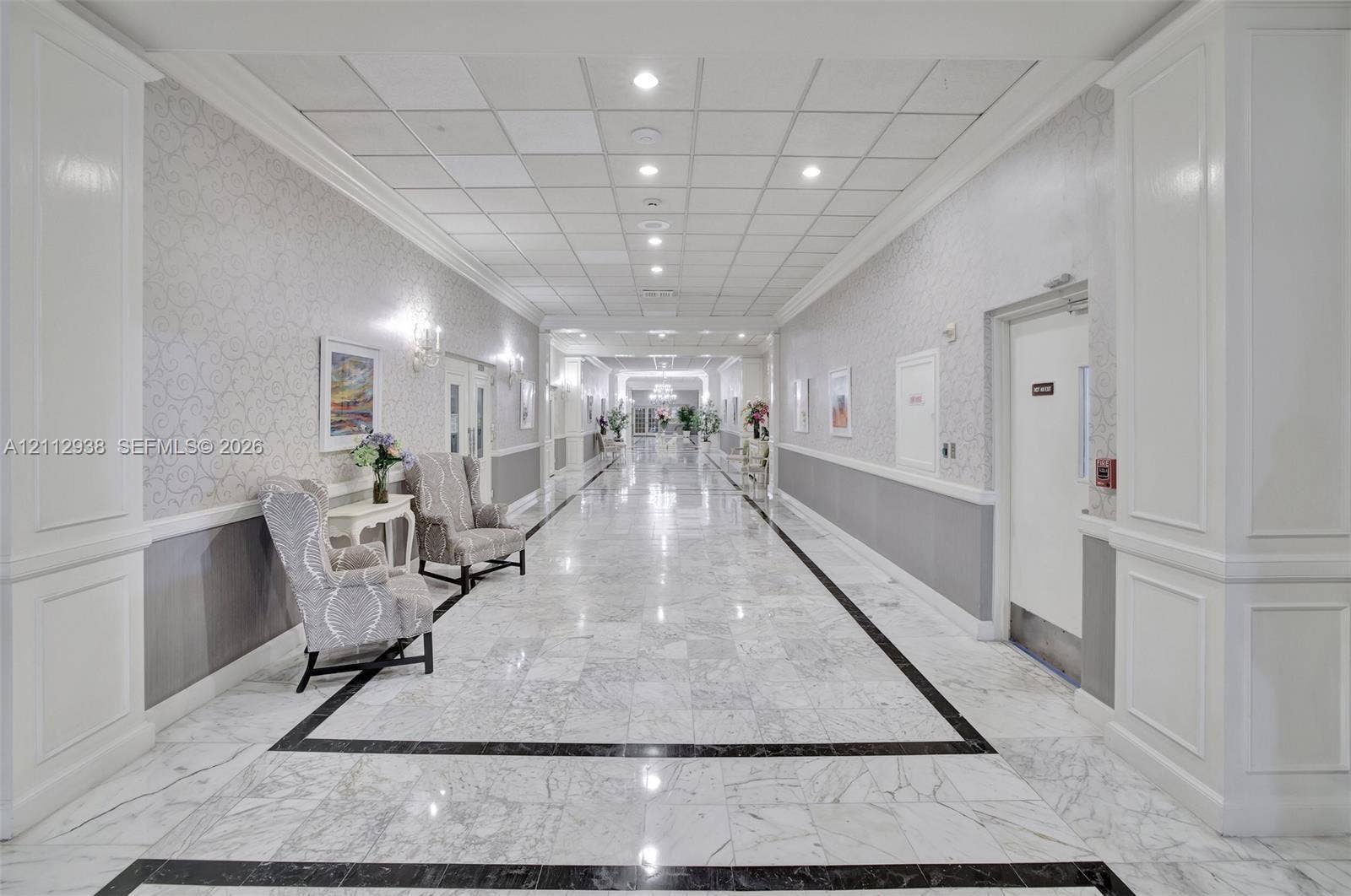 3800 S Ocean Drive, #801, Hollywood, FL 33019 Hallway featuring polished stone flooring with decorative inlay, wall molding, neutral wallpaper, and recessed ceiling lighting