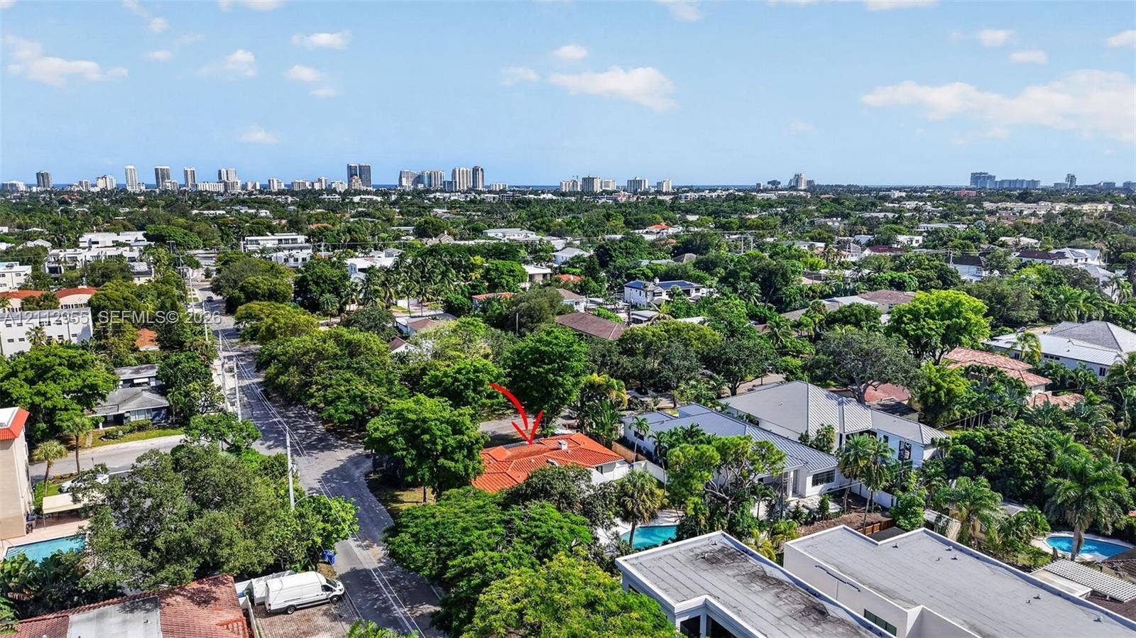 549 NE 12th Avenue, Fort Lauderdale, FL 33301 Aerial perspective of a residential property featuring a clay tile roof and dense mature tree canopy