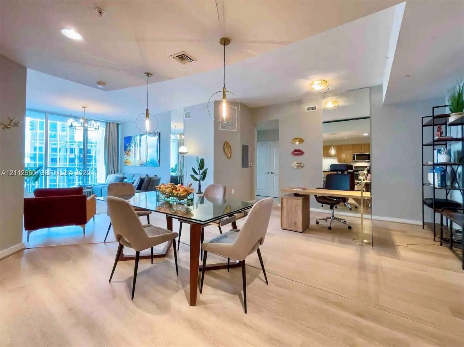 Open floor plan featuring wood-finish flooring, floor-to-ceiling windows, recessed lighting, and modern gold-tone pendant fixtures
