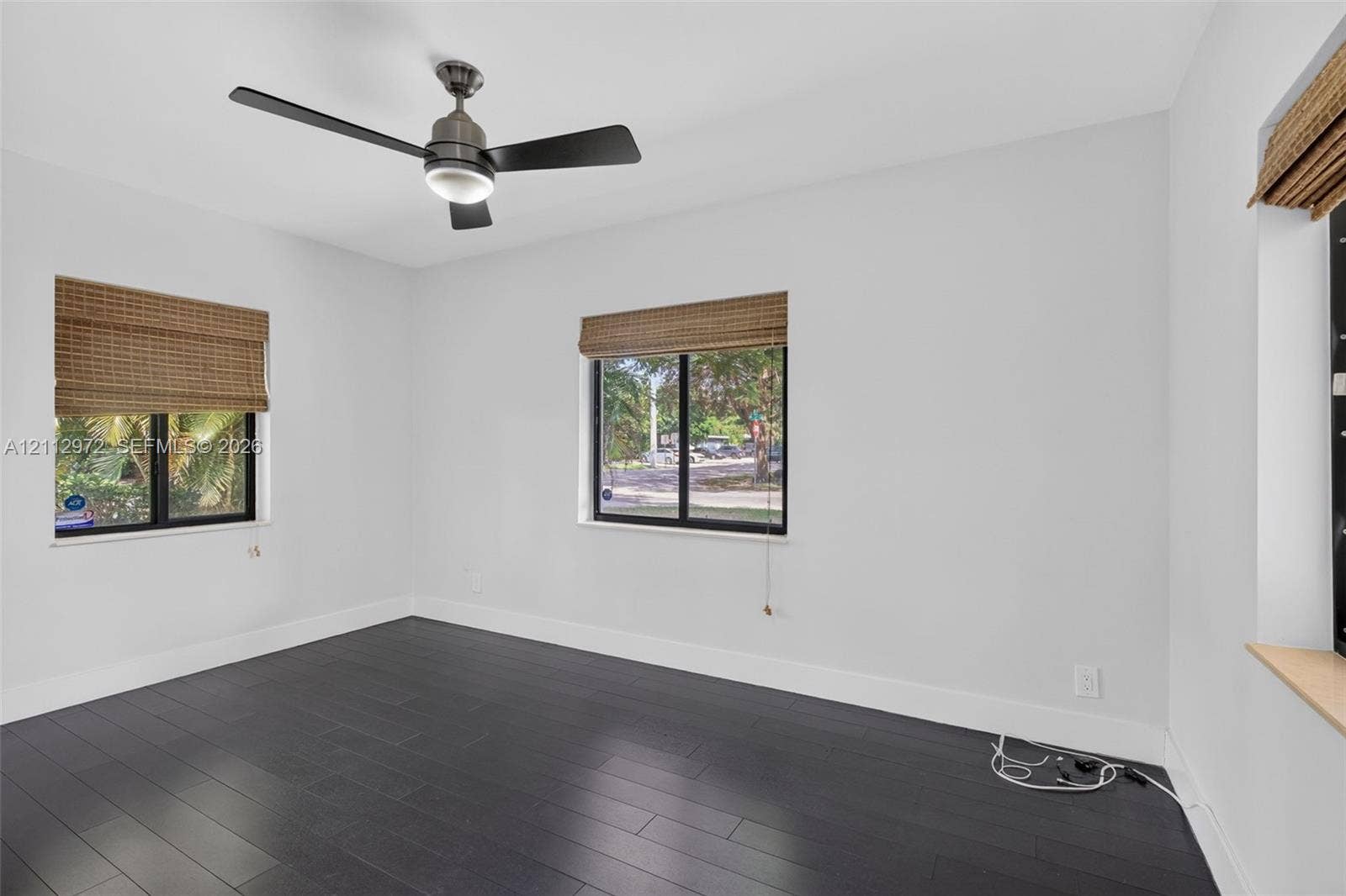 549 NE 12th Avenue, #0, Fort Lauderdale, Fort Lauderdale, FL 33301 Dark-toned wood-finish flooring, matte black ceiling fan with integrated lighting, and woven bamboo window shades