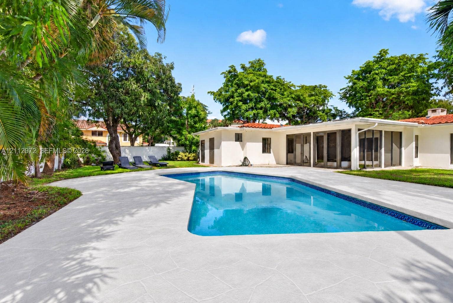 549 NE 12th Avenue, #0, Fort Lauderdale, Fort Lauderdale, FL 33301 Backyard featuring an in-ground swimming pool, expansive concrete patio, screened-in lanai, and mature landscaping
