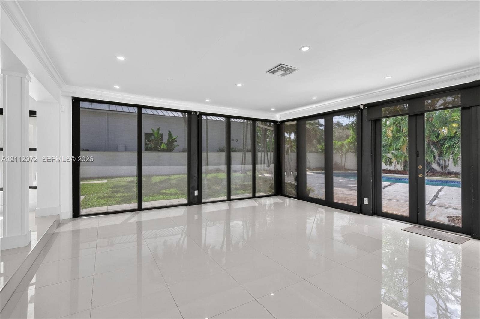 549 NE 12th Avenue, #0, Fort Lauderdale, Fort Lauderdale, FL 33301 Polished porcelain tile flooring, recessed LED lighting, and expansive floor-to-ceiling black-framed glass wall panels opening to a rear exterior patio and pool area