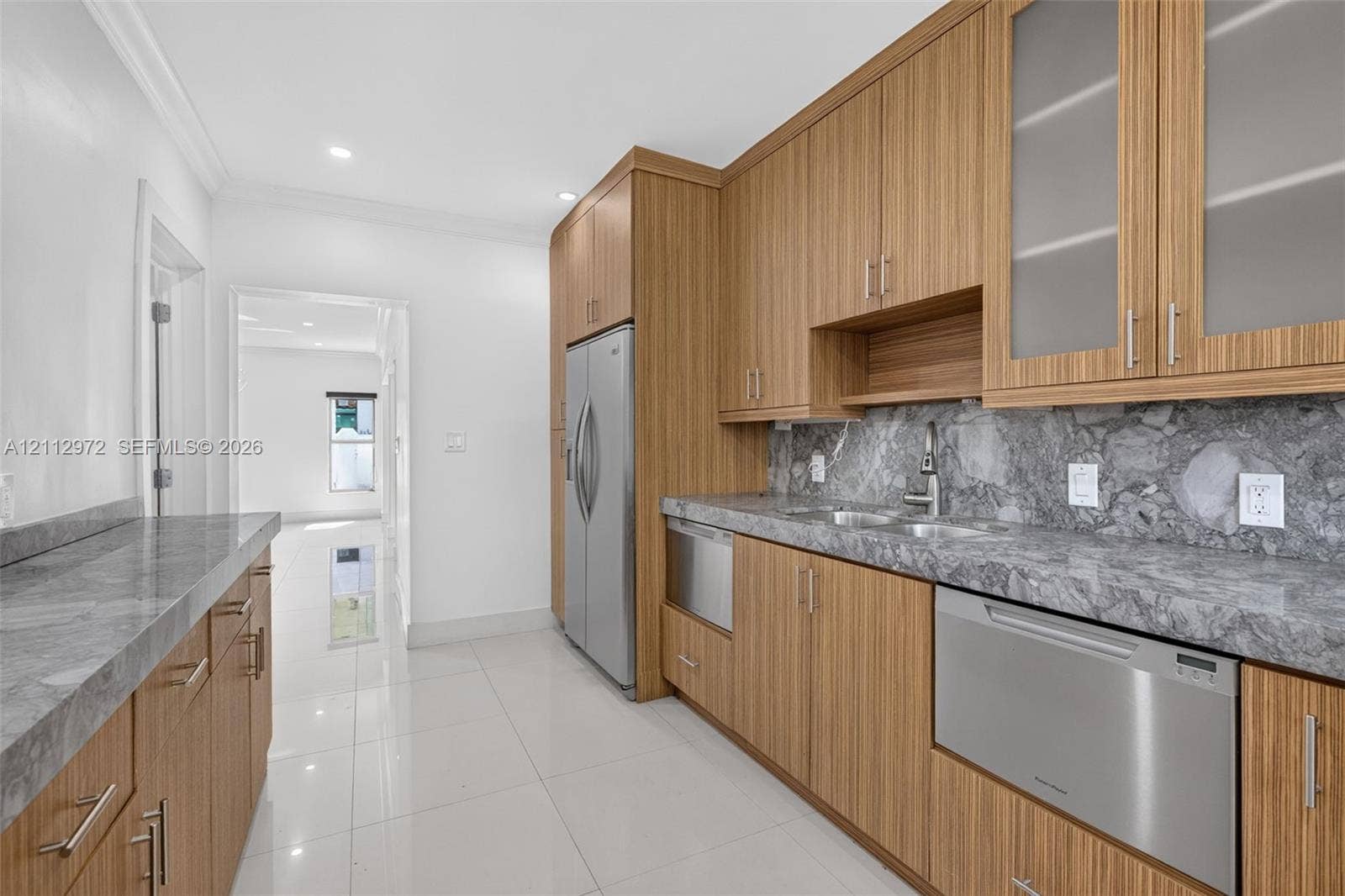 549 NE 12th Avenue, #0, Fort Lauderdale, Fort Lauderdale, FL 33301 Wood-finish cabinetry featuring glass-front upper cabinets, stainless steel appliances, stone-surface countertops, and high-gloss tile flooring