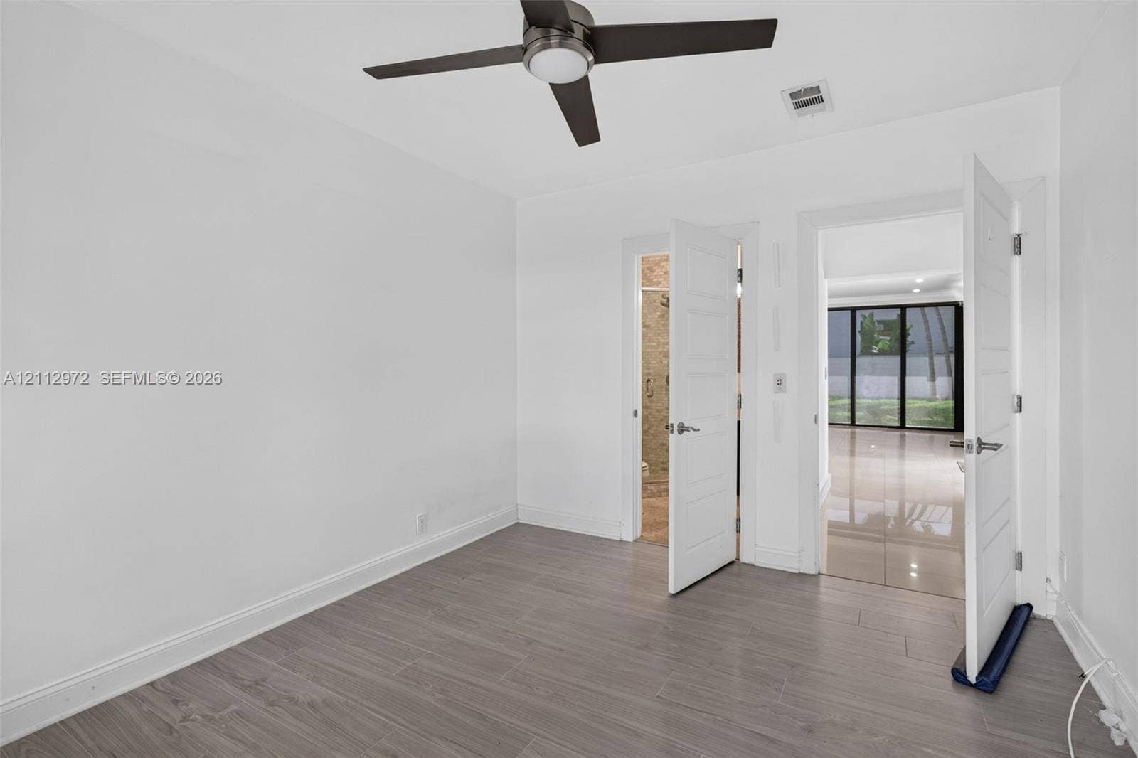 549 NE 12th Avenue, #0, Fort Lauderdale, Fort Lauderdale, FL 33301 Neutral-toned wood-finish flooring, ceiling fan with integrated light, and solid-core interior doors