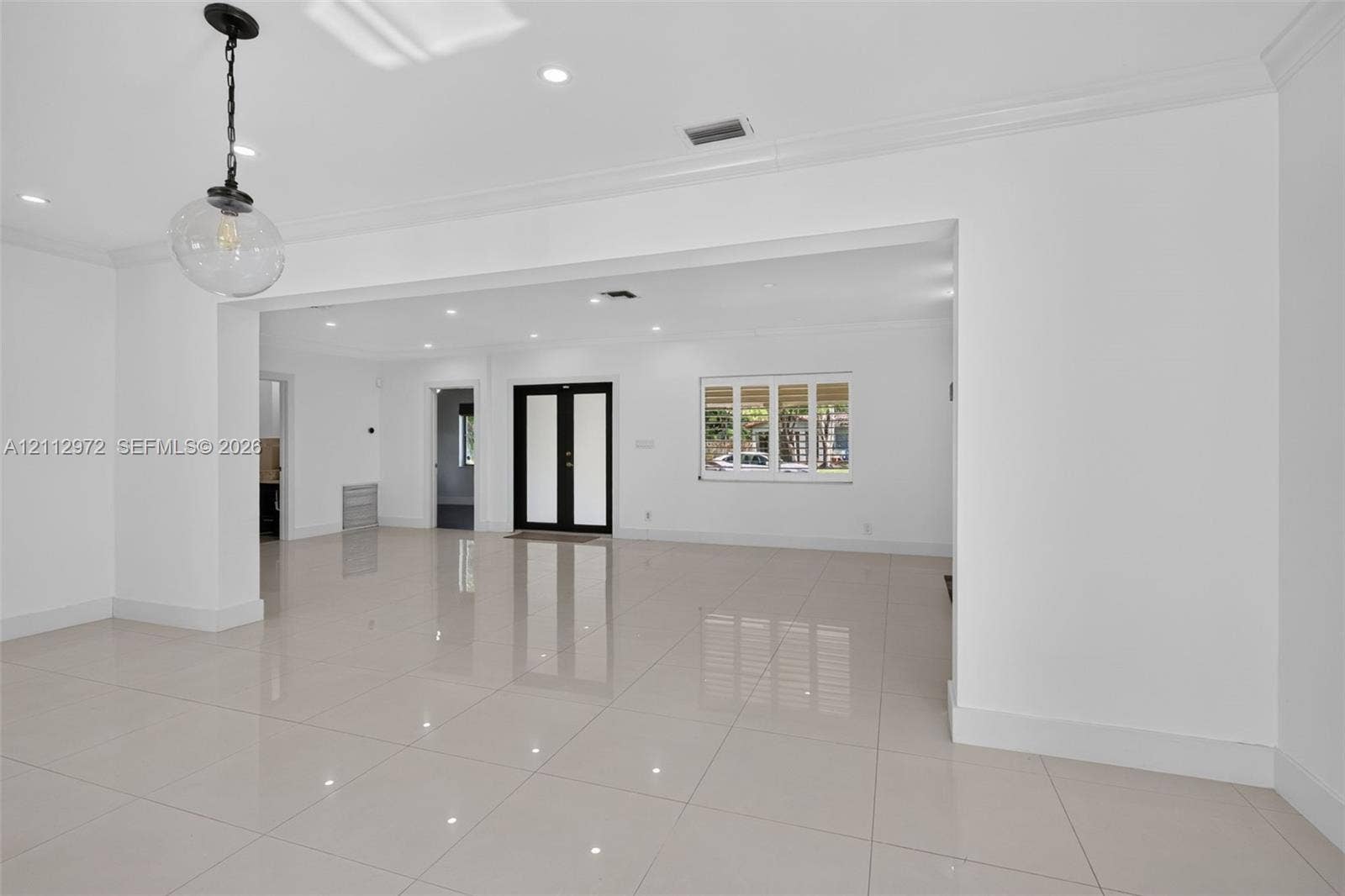 549 NE 12th Avenue, #0, Fort Lauderdale, Fort Lauderdale, FL 33301 Open-concept interior featuring large-format porcelain tile flooring, crown molding, recessed lighting, double entry doors, and a decorative glass pendant light fixture