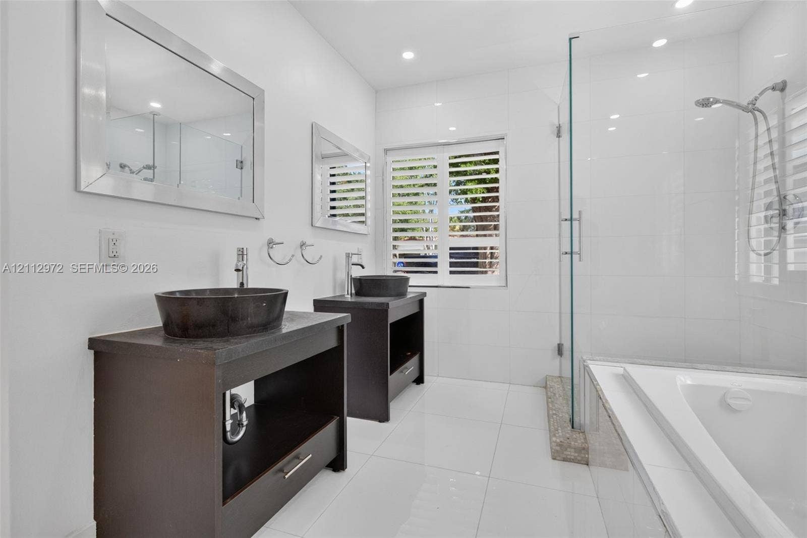 549 NE 12th Avenue, #0, Fort Lauderdale, Fort Lauderdale, FL 33301 Bathroom featuring dual dark wood vanities with vessel sinks, a glass-enclosed shower, a deep soaking tub, and plantation shutters