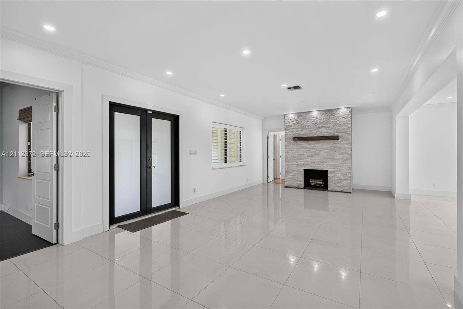 549 NE 12th Avenue, #0, Fort Lauderdale, Fort Lauderdale, FL 33301 Large-format tile flooring, recessed ceiling lighting, stone-veneer fireplace with a wood mantel, and black-framed glass panel double doors