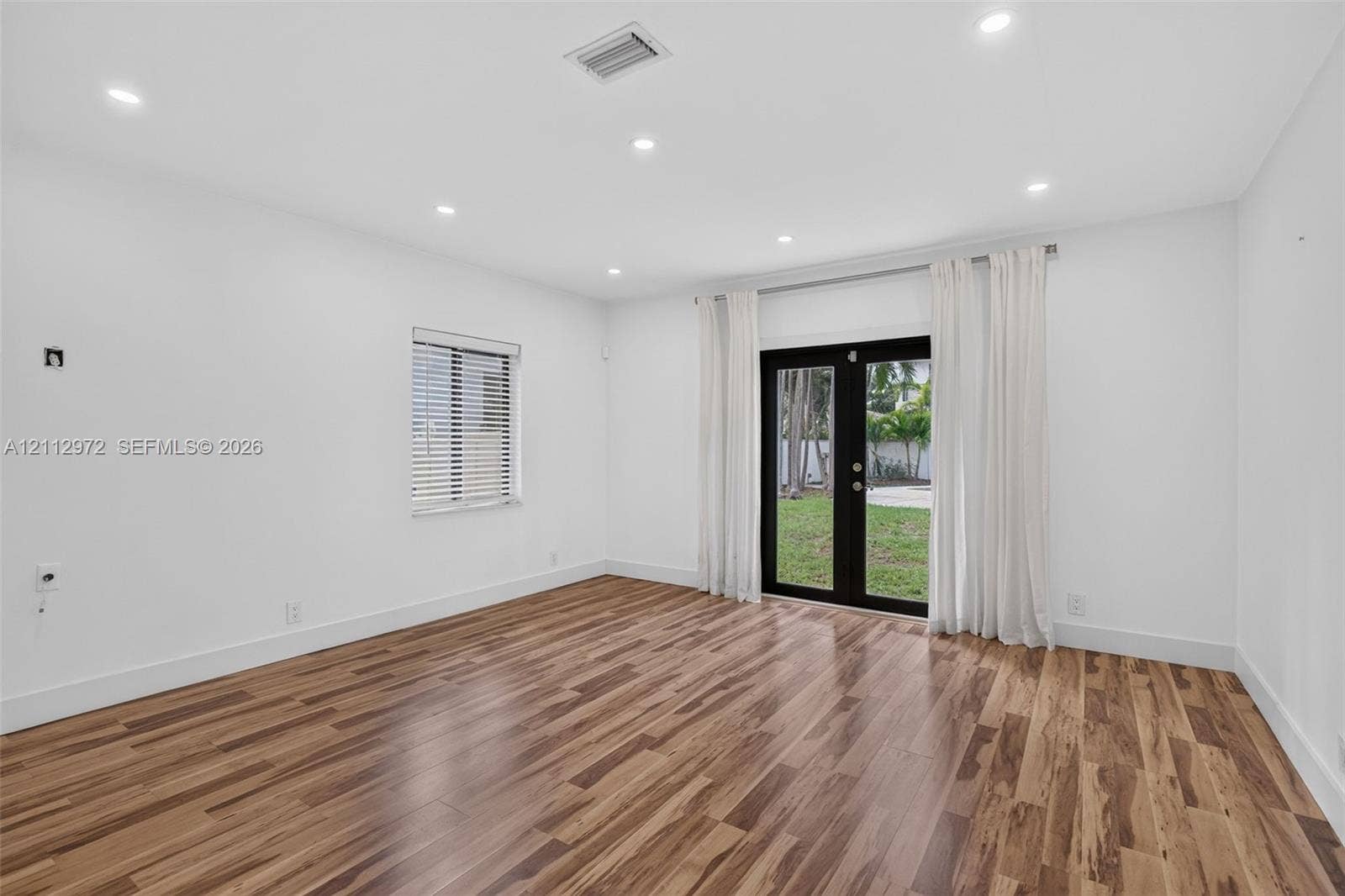 549 NE 12th Avenue, #0, Fort Lauderdale, Fort Lauderdale, FL 33301 Interior space featuring wood-finish flooring, recessed lighting, and black-framed double glass doors providing an exterior perspective