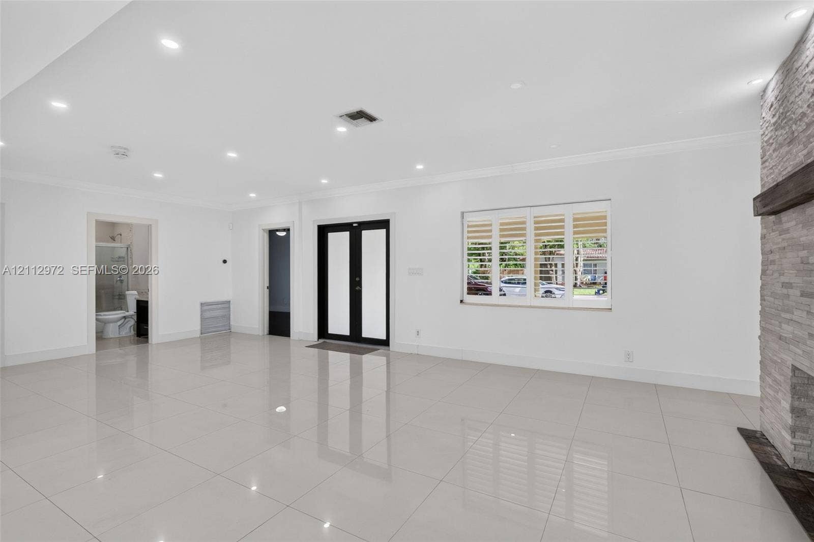 549 NE 12th Avenue, #0, Fort Lauderdale, Fort Lauderdale, FL 33301 Large-format tile flooring, recessed ceiling lighting, stone-clad fireplace with a timber mantel, double-entry front door with glass insets, and windows featuring plantation shutters