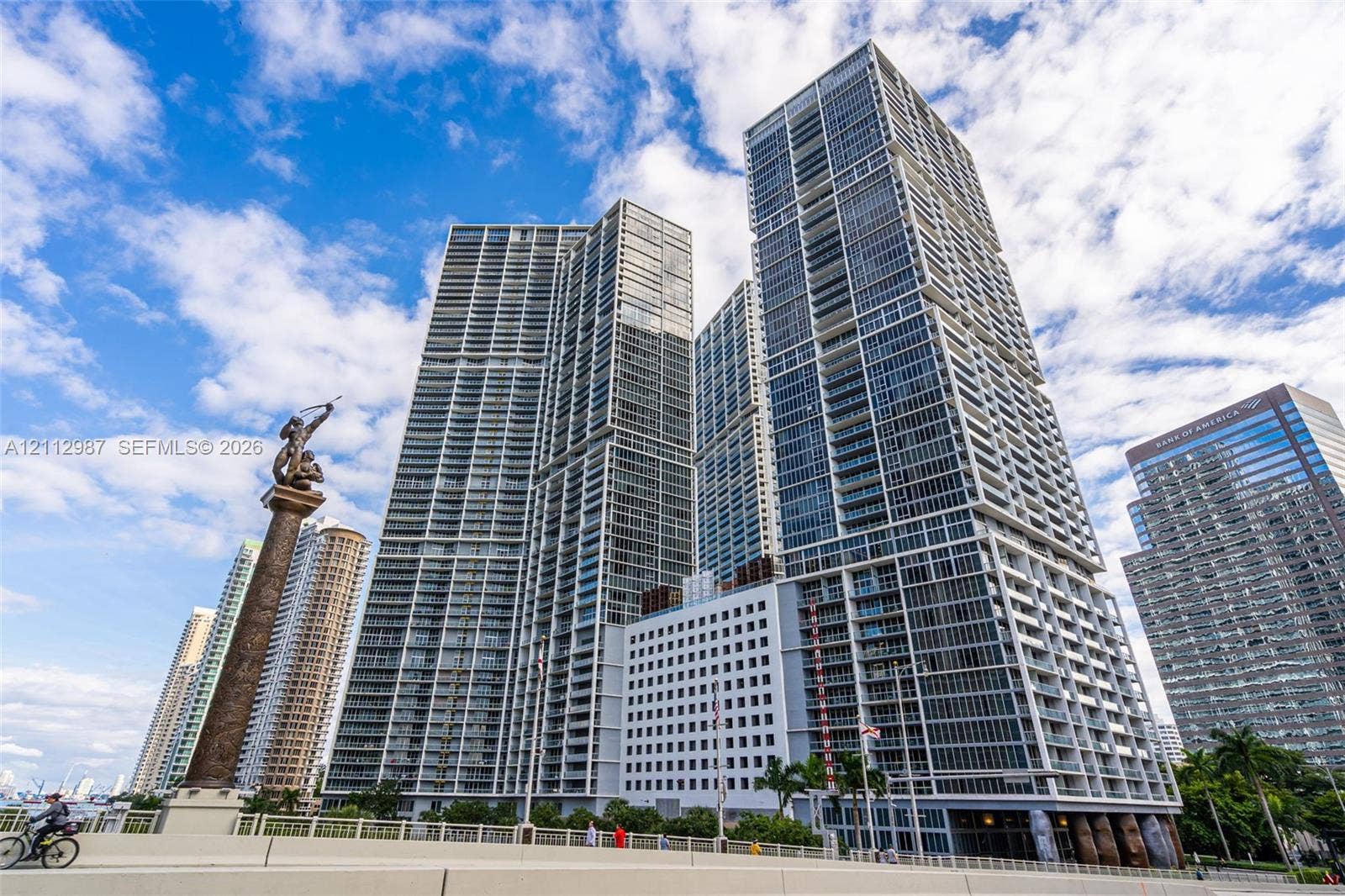 High-rise residential tower featuring glass-curtain wall construction, expansive balconies, and geometric architectural detailing