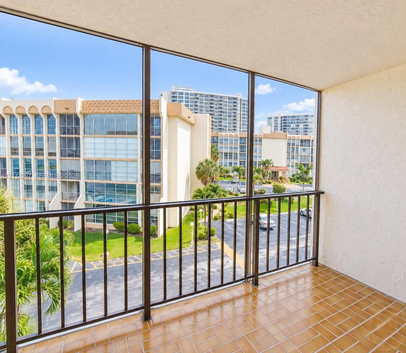 Screened-in balcony featuring tile flooring and metal railings
