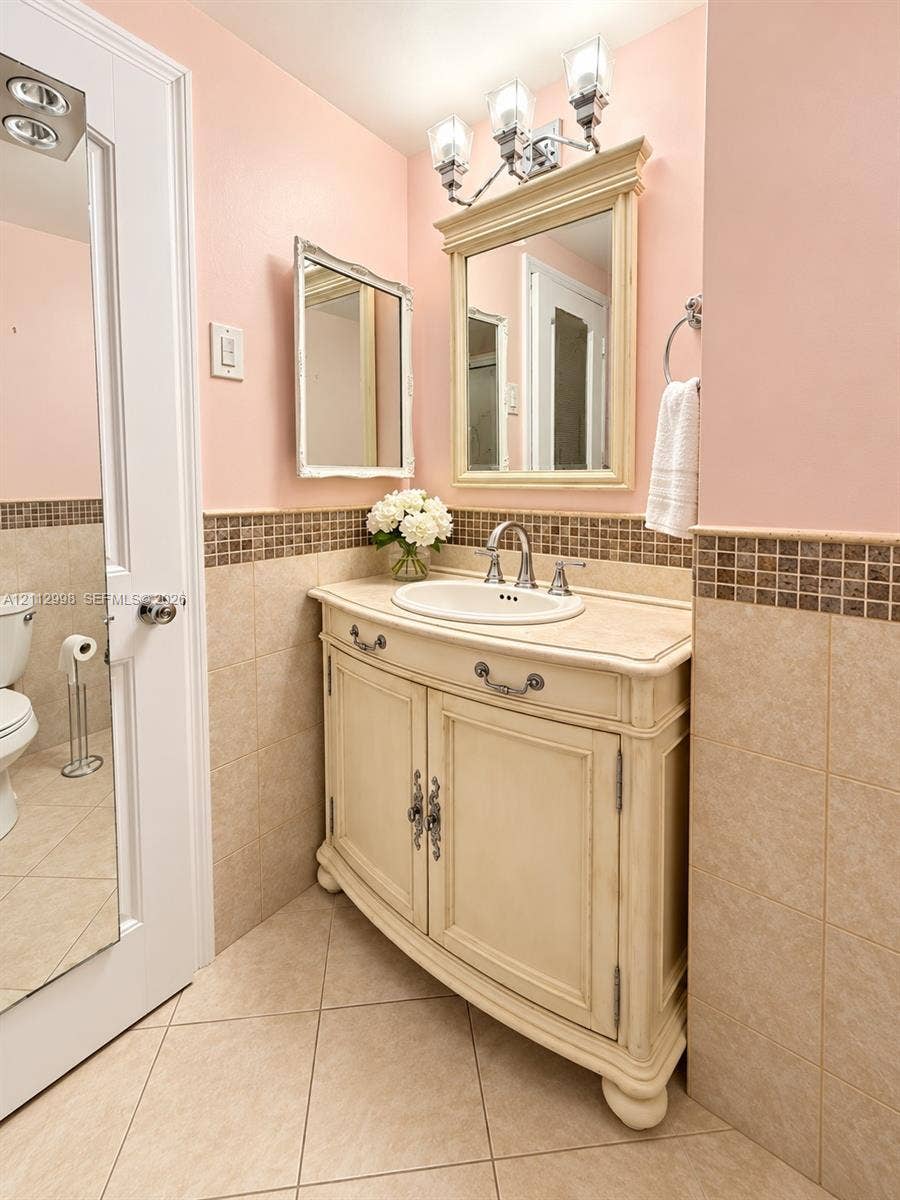 Vanity featuring a stone countertop, an integrated oval basin, and antique-style cabinetry with decorative hardware