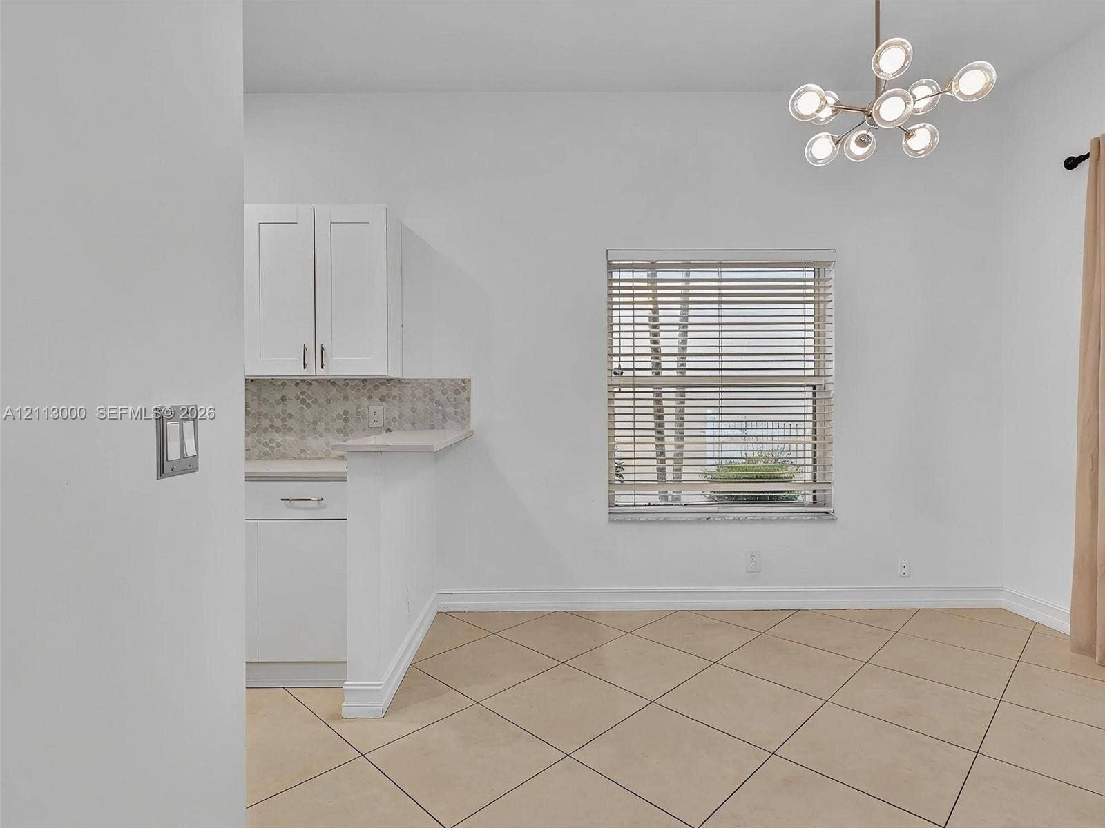 10860 La Salinas Circle, Boca Raton, FL 33428 Modern multi-light pendant fixture, white shaker-style cabinetry, mosaic tile backsplash, and diagonal-set tile flooring