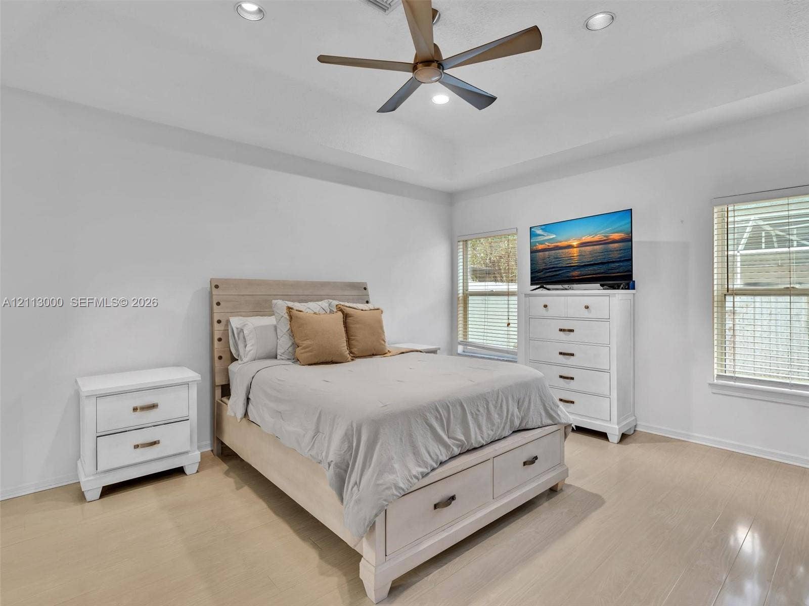 10860 La Salinas Circle, Boca Raton, FL 33428 Tray ceiling with recessed lighting, multi-blade ceiling fan, and light-toned wood-finish flooring
