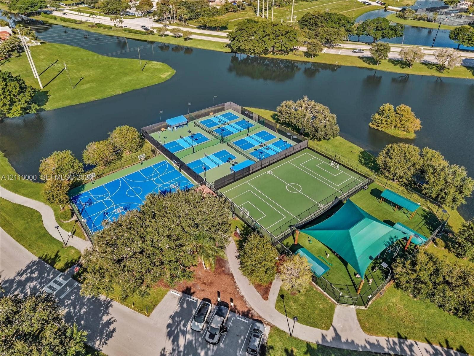 10860 La Salinas Circle, Boca Raton, FL 33428 Recreational complex featuring four fenced tennis courts, a basketball court, a multi-use turf field, and a shaded pavilion