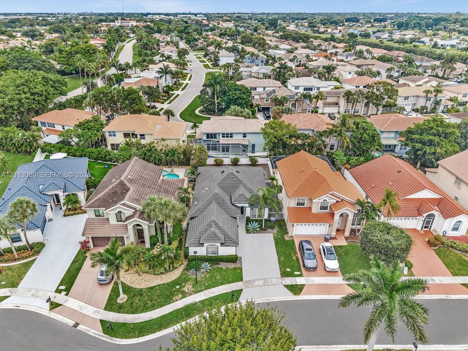 10860 La Salinas Circle, Boca Raton, FL 33428 Aerial perspective of a suburban neighborhood featuring multi-story single-family residences, concrete driveways, tile roofing, and mature landscaping