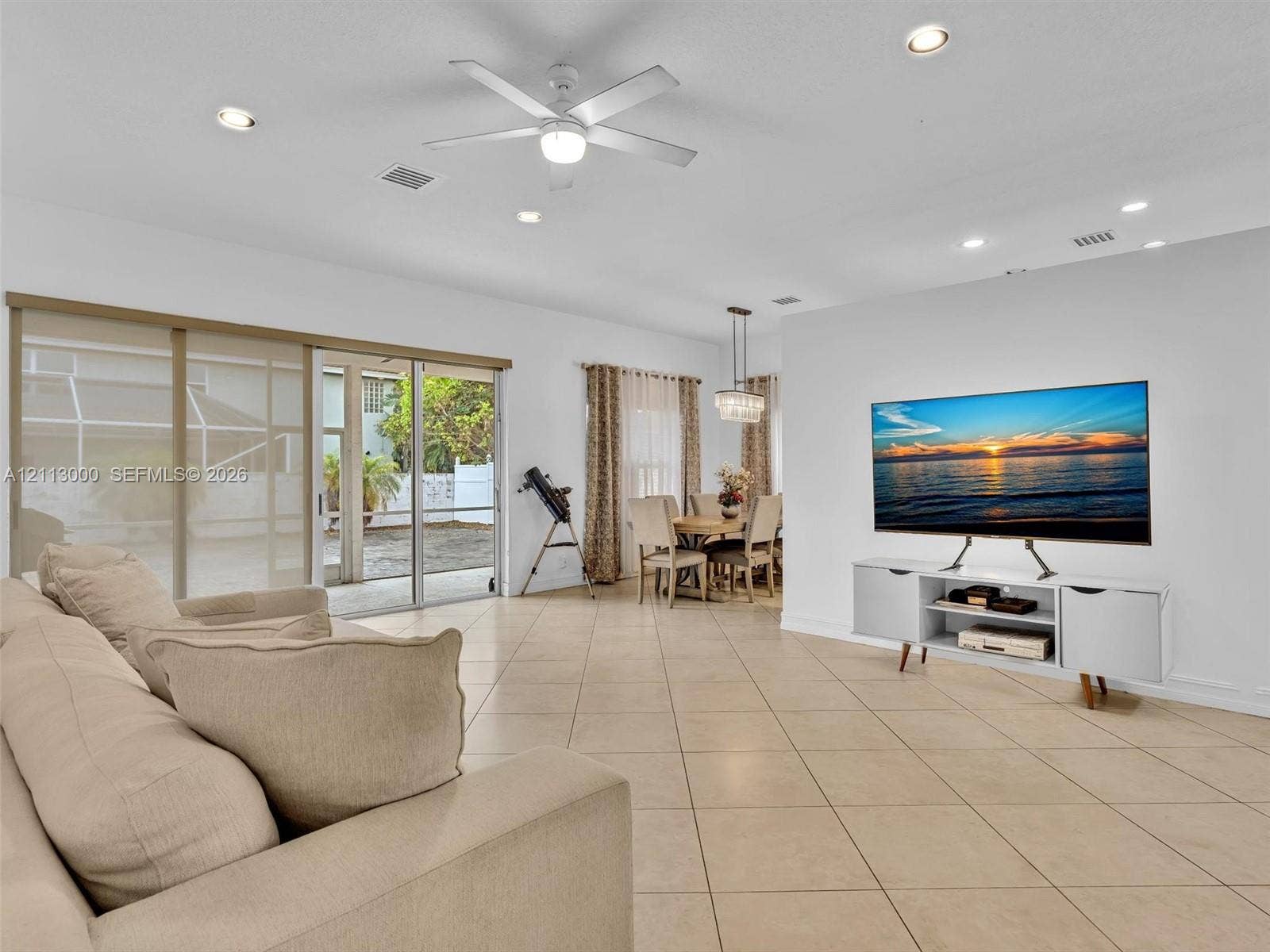 10860 La Salinas Circle, Boca Raton, FL 33428 Large-format neutral tile flooring, recessed ceiling lighting, central ceiling fan, and expansive sliding glass doors
