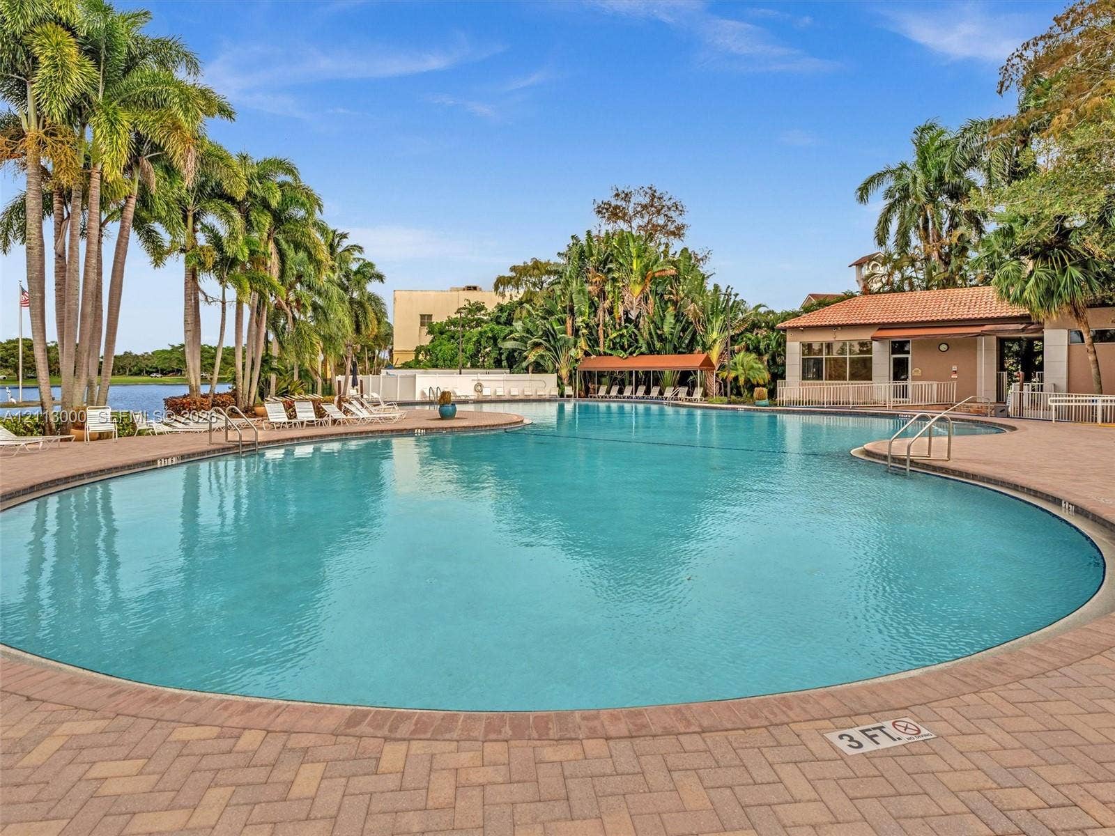 10860 La Salinas Circle, Boca Raton, FL 33428 Large community swimming pool with brick paver decking, sheltered seating area, and mature palm landscaping