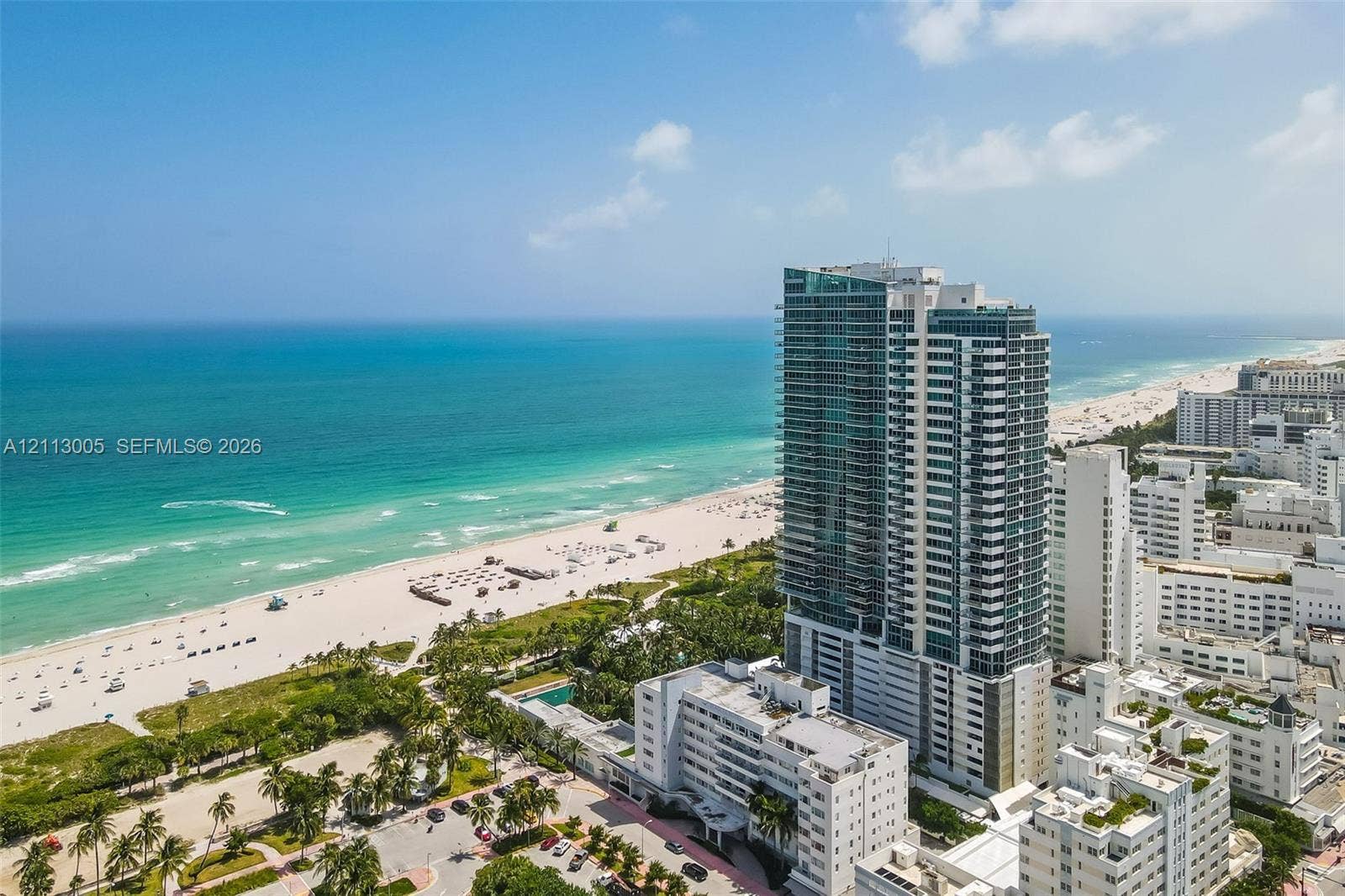 High-rise tower featuring glass-paneled facades, expansive exterior balconies, and direct proximity to the oceanfront