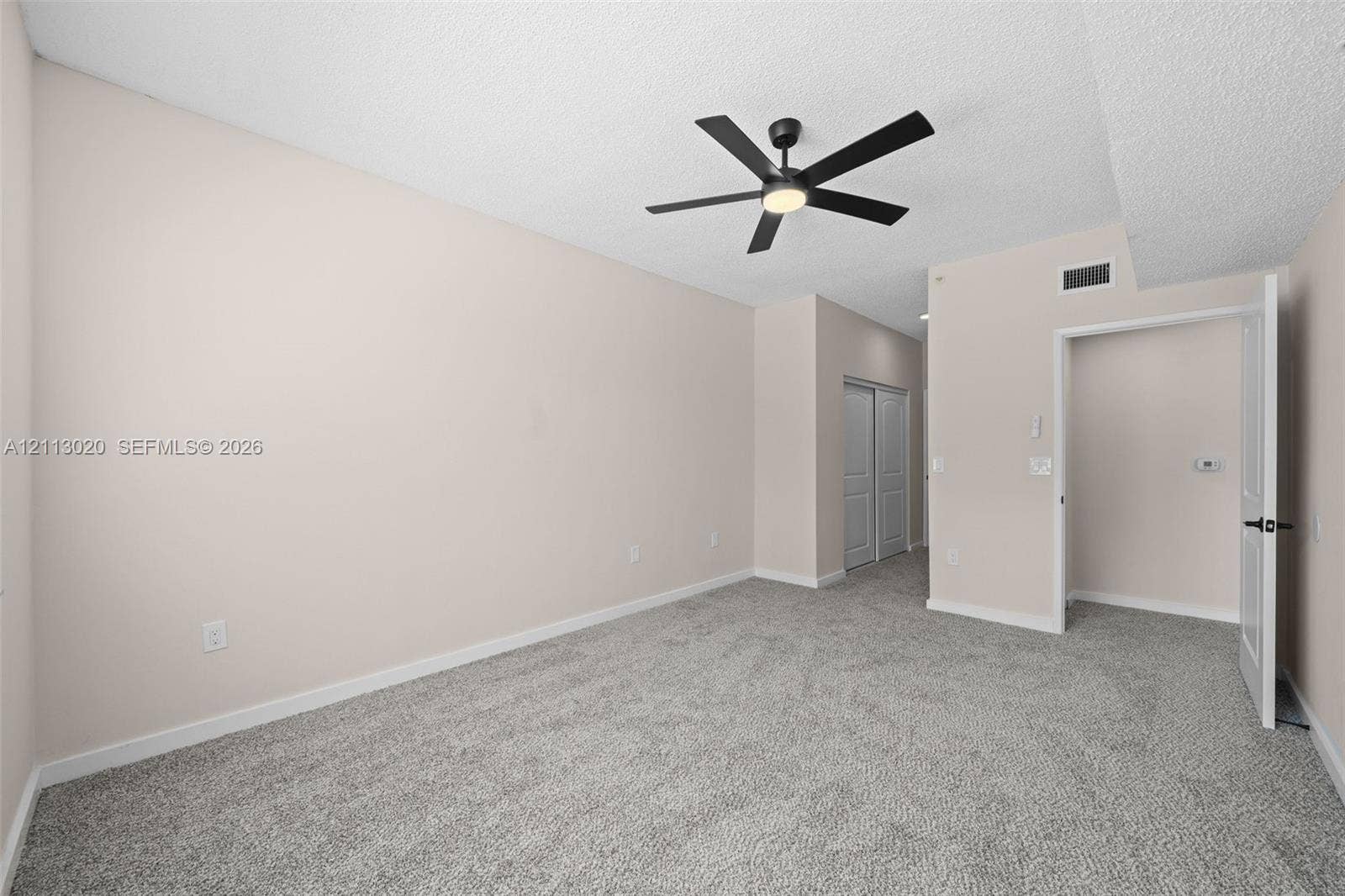 6968 SW 39th Street, #F104, Davie, Davie, FL 33314 Neutral wall paint, ceiling fan with integrated lighting, wall-to-wall carpeting, and dual-panel closet doors