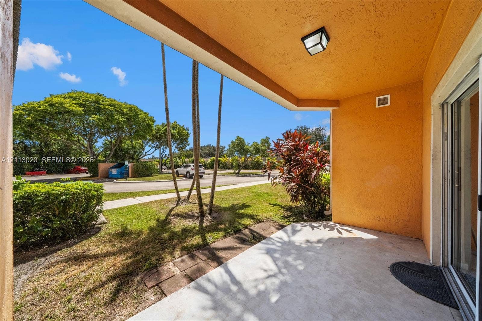 6968 SW 39th Street, #F104, Davie, Davie, FL 33314 Covered concrete patio featuring a stucco ceiling, flush-mount lighting, and sliding glass door entry
