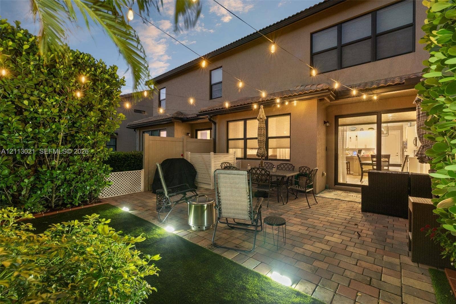 8228 Tailshot Court, Lake Worth, Lake Worth, FL 33467 Paver patio featuring integrated landscape lighting, artificial turf, and privacy fencing
