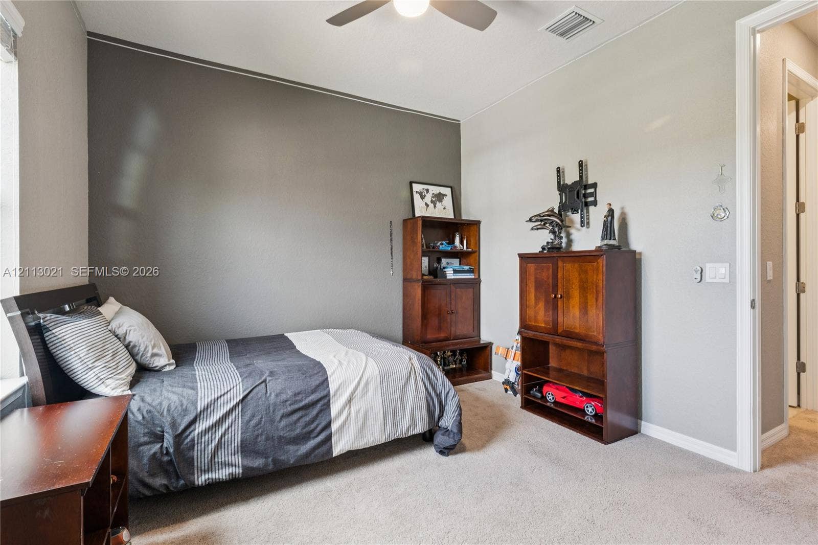 8228 Tailshot Court, Lake Worth, Lake Worth, FL 33467 Interior room featuring a neutral color palette, charcoal accent wall, neutral carpeting, and a ceiling-mounted fan with light fixture