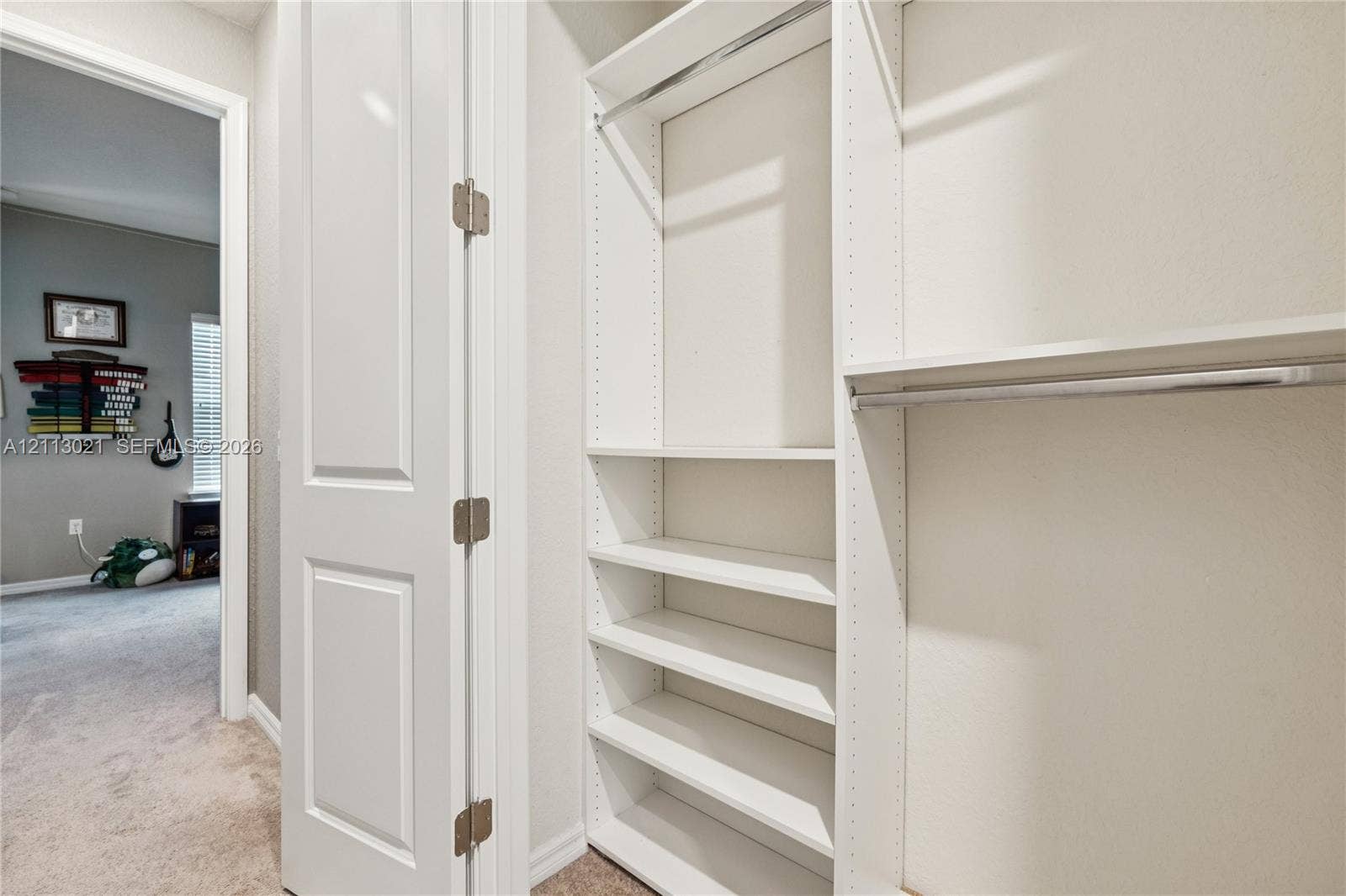 8228 Tailshot Court, Lake Worth, Lake Worth, FL 33467 Custom built-in closet organization featuring adjustable shelving, integrated hanging rods, and a white finish