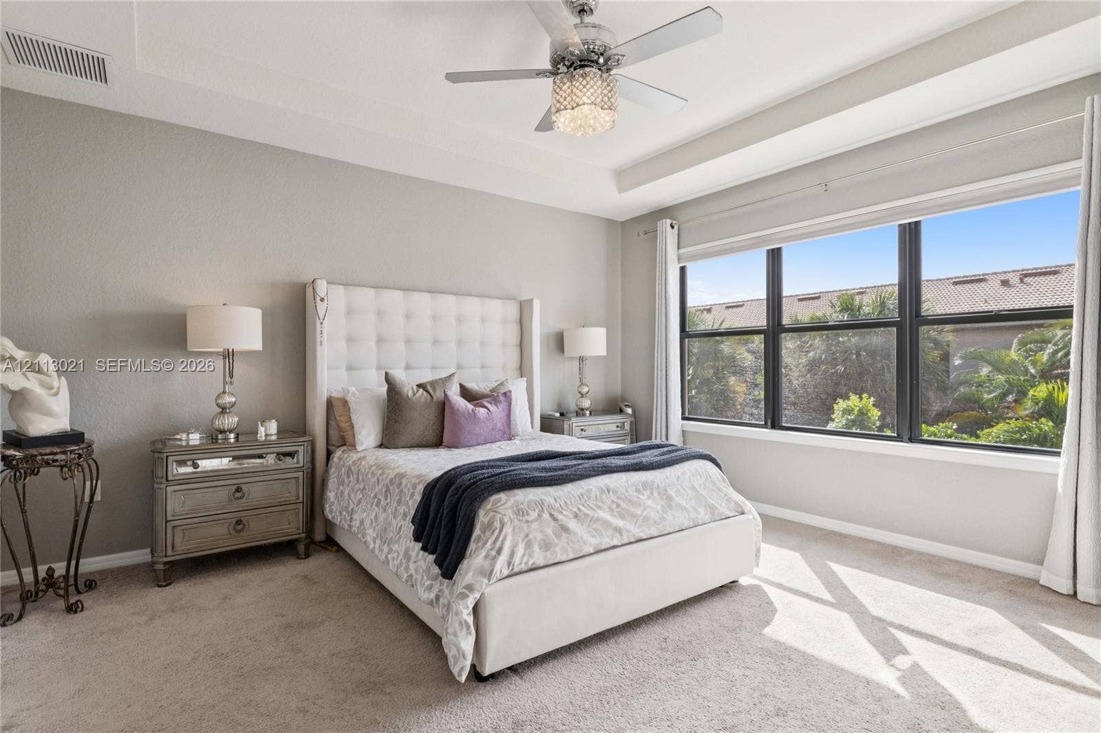 8228 Tailshot Court, Lake Worth, Lake Worth, FL 33467 Tray ceiling, large multi-pane window, and decorative ceiling fan with integrated crystal-style lighting
