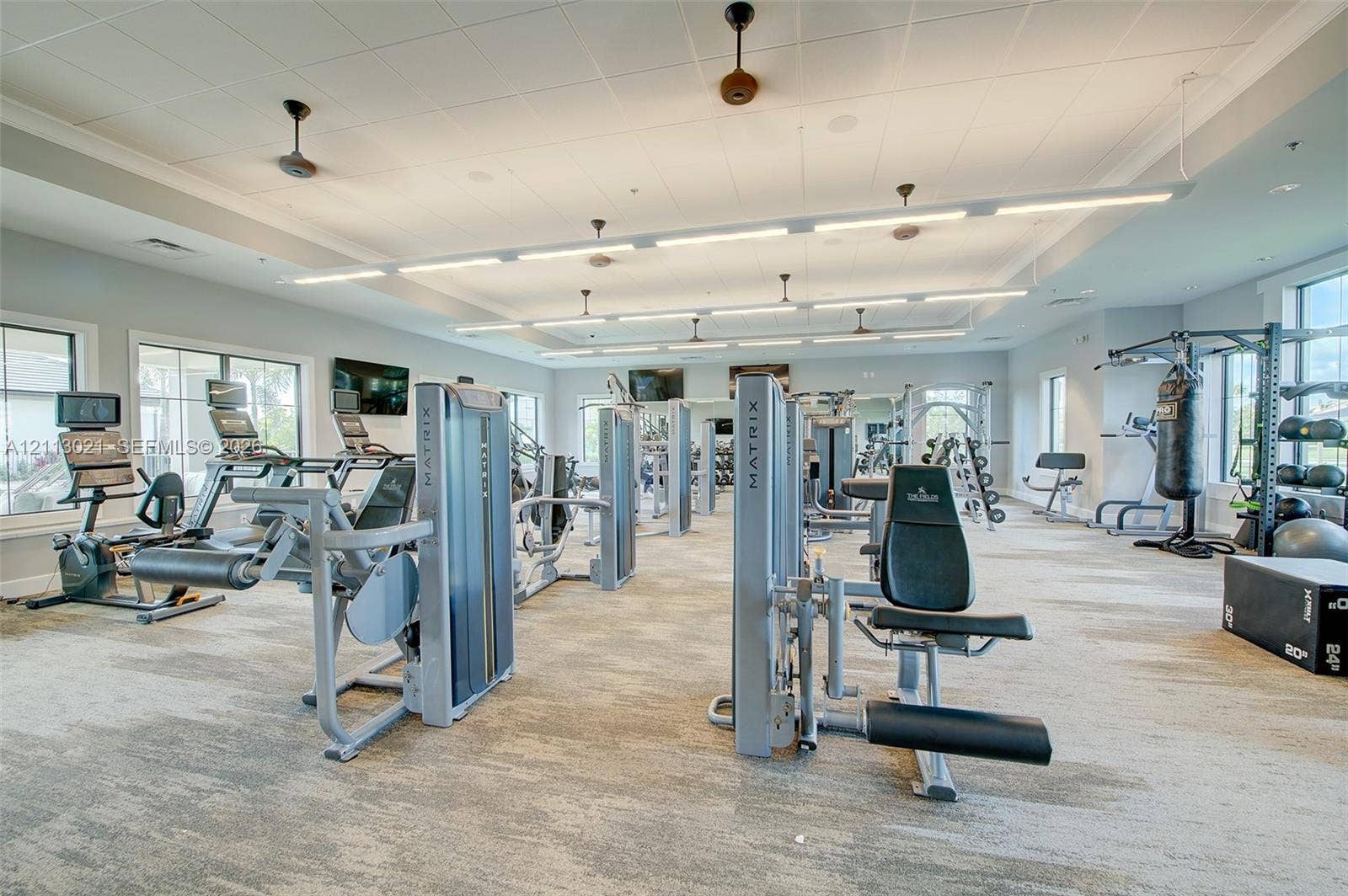 8228 Tailshot Court, Lake Worth, Lake Worth, FL 33467 Fitness center featuring linear LED overhead lighting, drop ceiling panels, multi-tonal carpeting, and an array of weight-training and cardio equipment