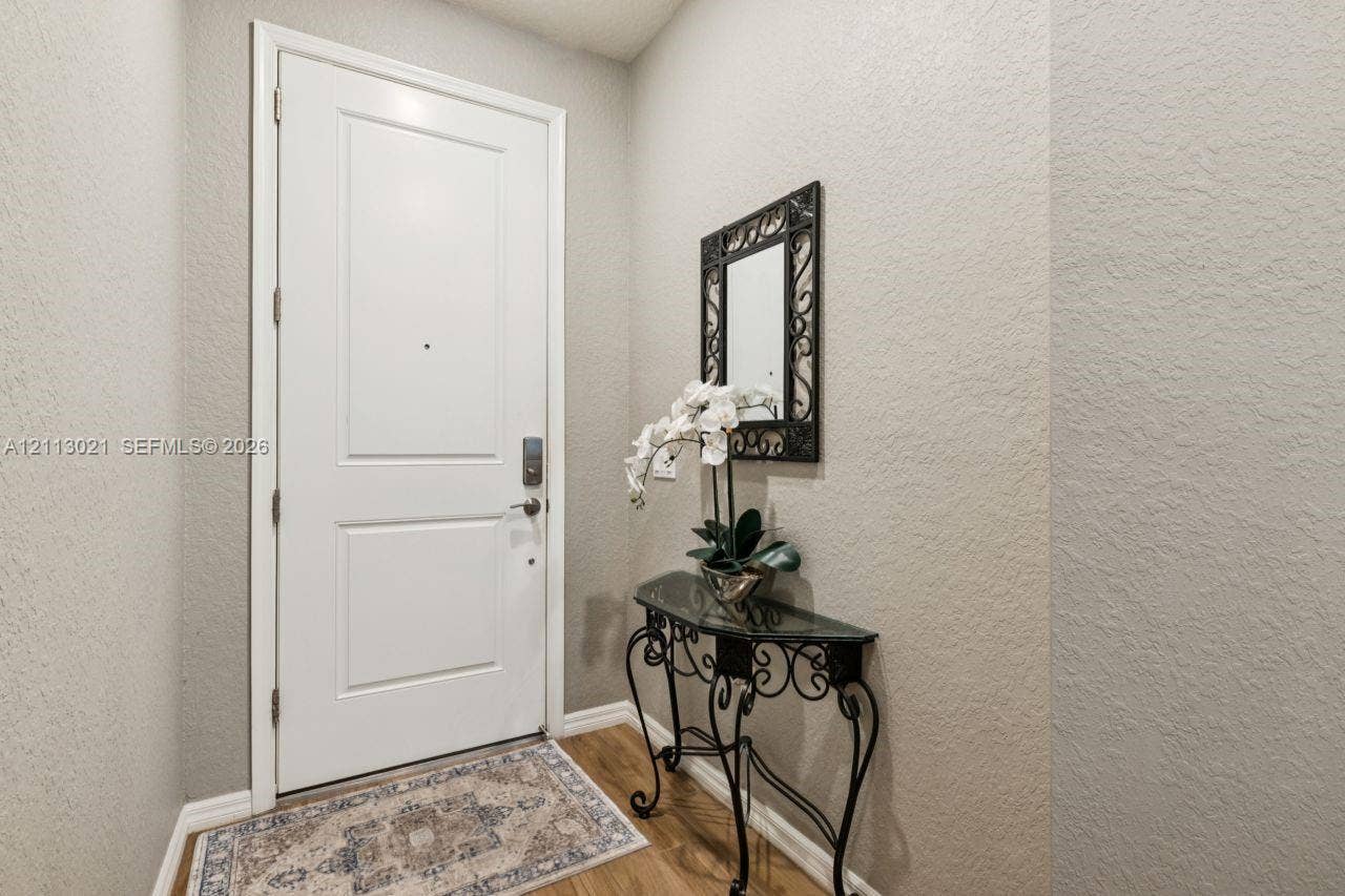 8228 Tailshot Court, Lake Worth, Lake Worth, FL 33467 Solid core paneled door with brushed metallic hardware and wood-finish flooring