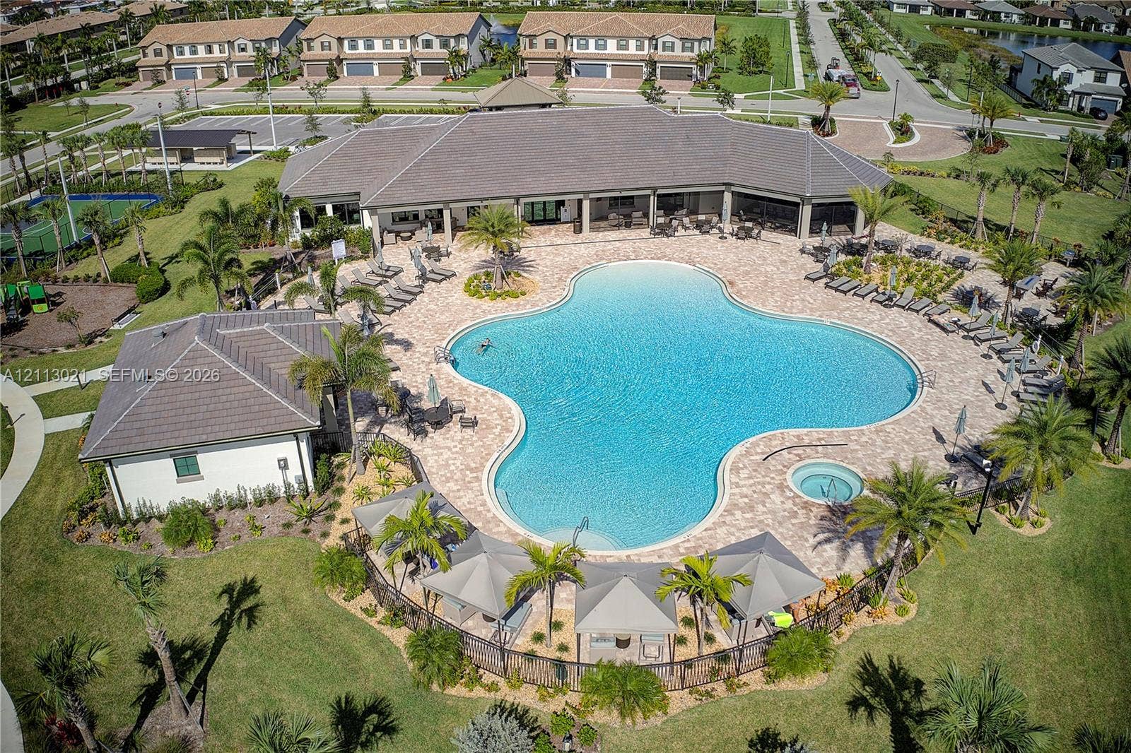 8228 Tailshot Court, Lake Worth, Lake Worth, FL 33467 Community clubhouse featuring a large swimming pool, an integrated spa, paver pool deck, and shaded cabanas surrounded by landscaped grounds