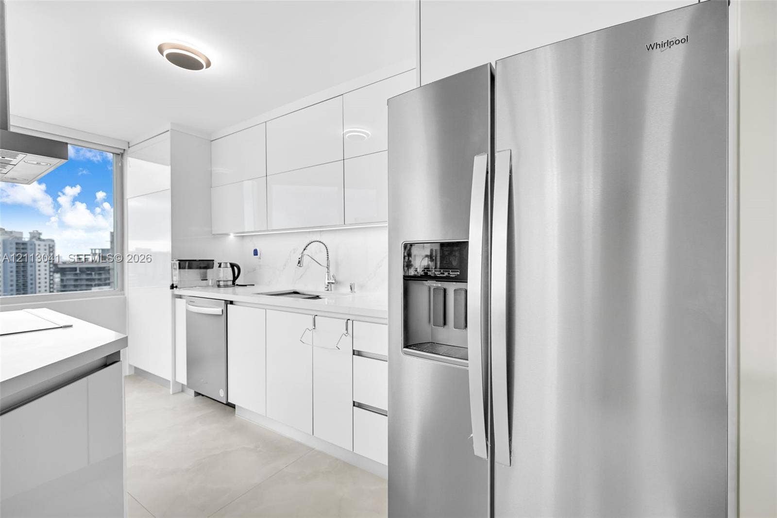 7135 Collins Avenue, #1426, Miami Beach, FL 33141 Kitchen featuring high-gloss white cabinetry, stone-surface countertops, stainless steel side-by-side refrigerator, stainless steel dishwasher, and large-format tile flooring