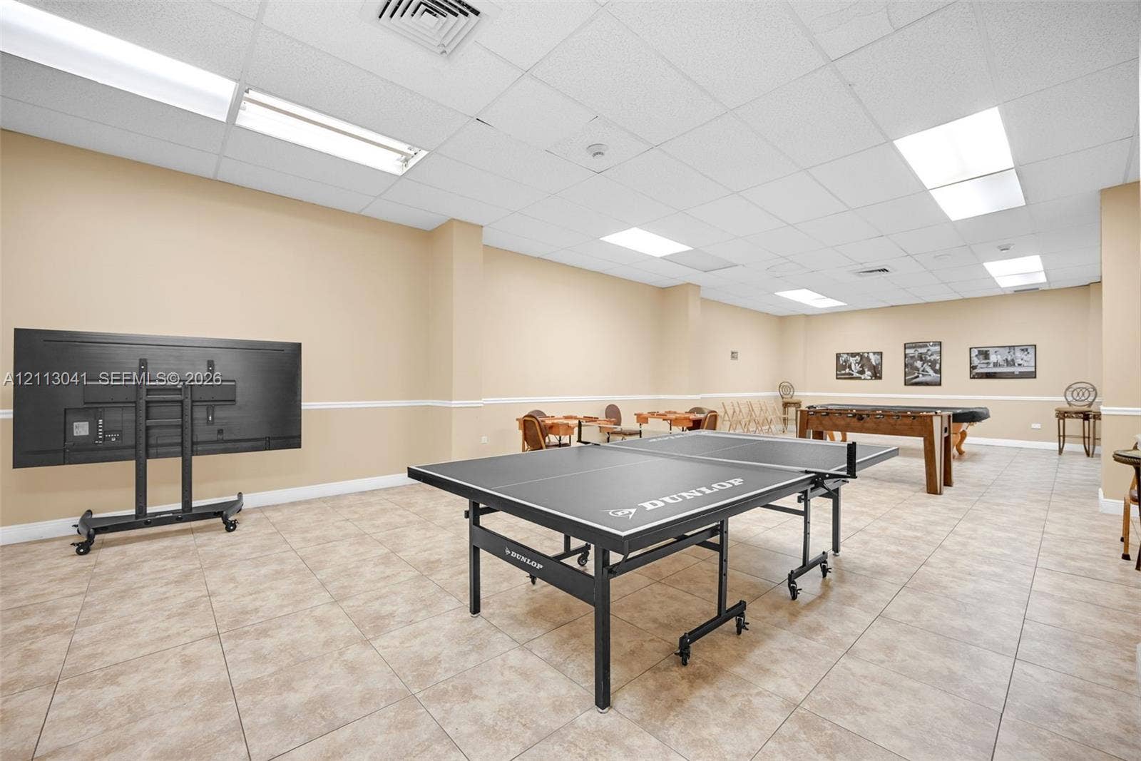 7135 Collins Avenue, #1426, Miami Beach, FL 33141 Open-concept interior space featuring neutral wall paint, tile flooring, recessed drop-ceiling grid lighting, and chair rail molding