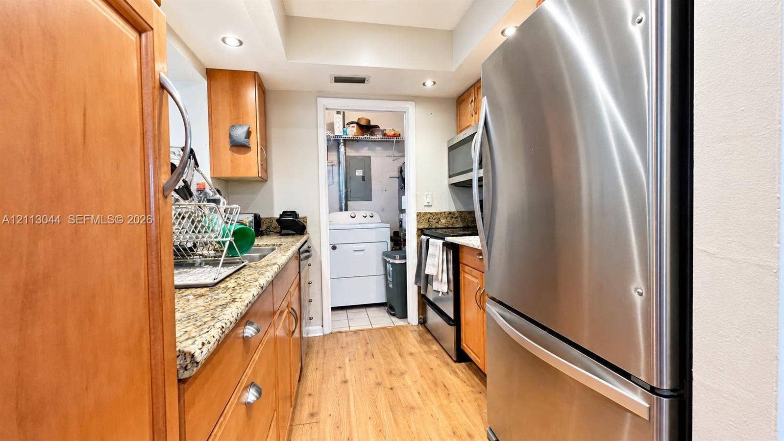 6735 NW 62nd Street, Tamarac, FL 33321 Kitchen featuring wood cabinetry, stone countertops, stainless steel appliances, recessed lighting, and wood-finish flooring