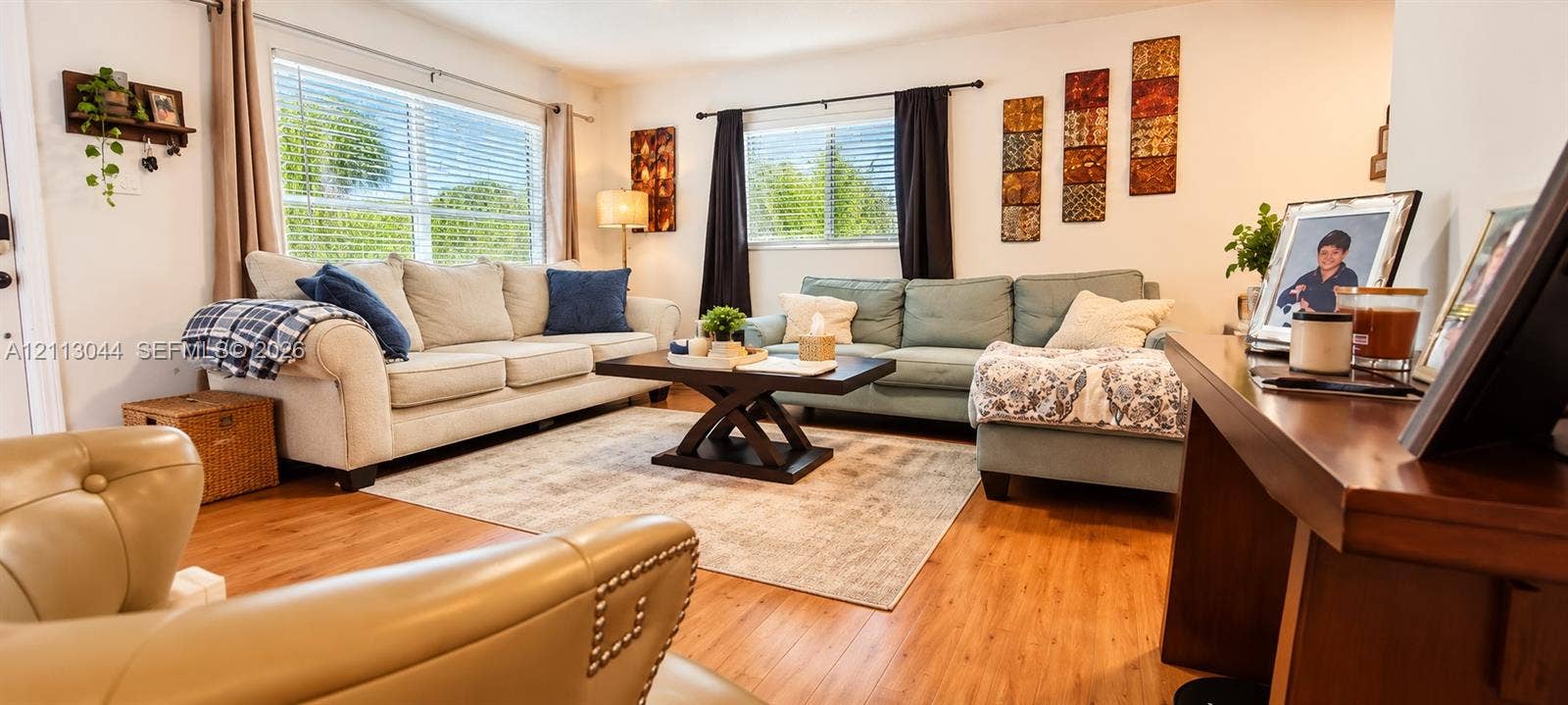 6735 NW 62nd Street, Tamarac, FL 33321 Living area featuring wood-finish flooring and dual windows with horizontal blinds