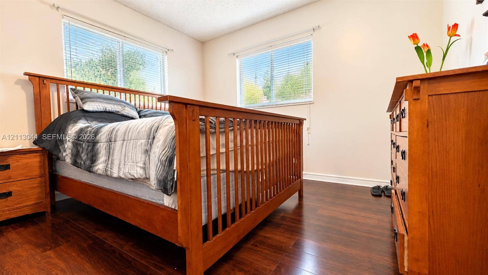 6735 NW 62nd Street, Tamarac, FL 33321 Room featuring dark wood-finish flooring and two windows with horizontal blinds