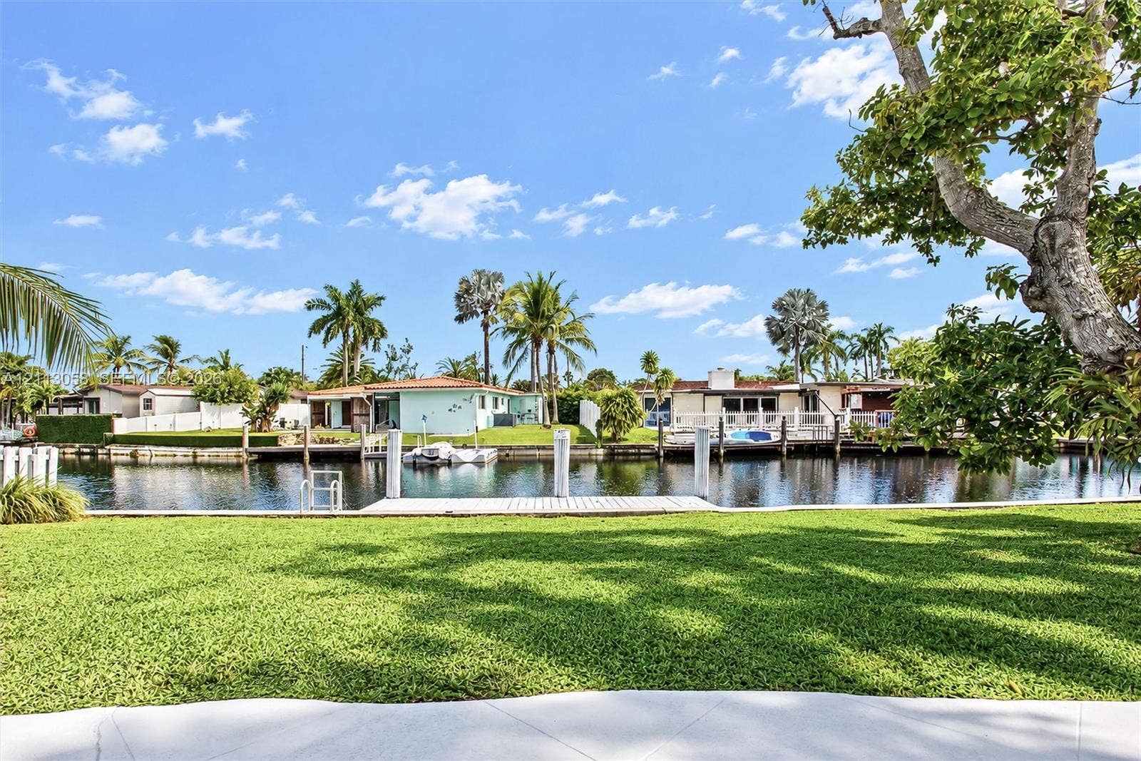 1980 NW 33rd Court, Oakland Park, FL 33309 Waterfront lot featuring a manicured lawn, concrete seawall, and private dock