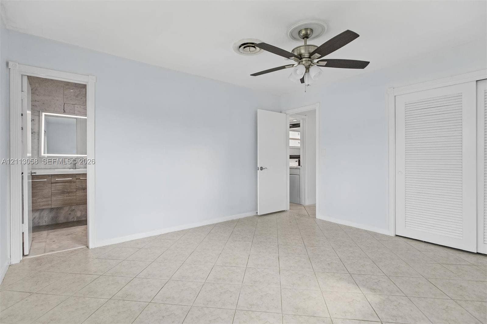 1980 NW 33rd Court, Oakland Park, FL 33309 Room featuring tile flooring, ceiling fan with integrated lighting, and dual-door louvered closet