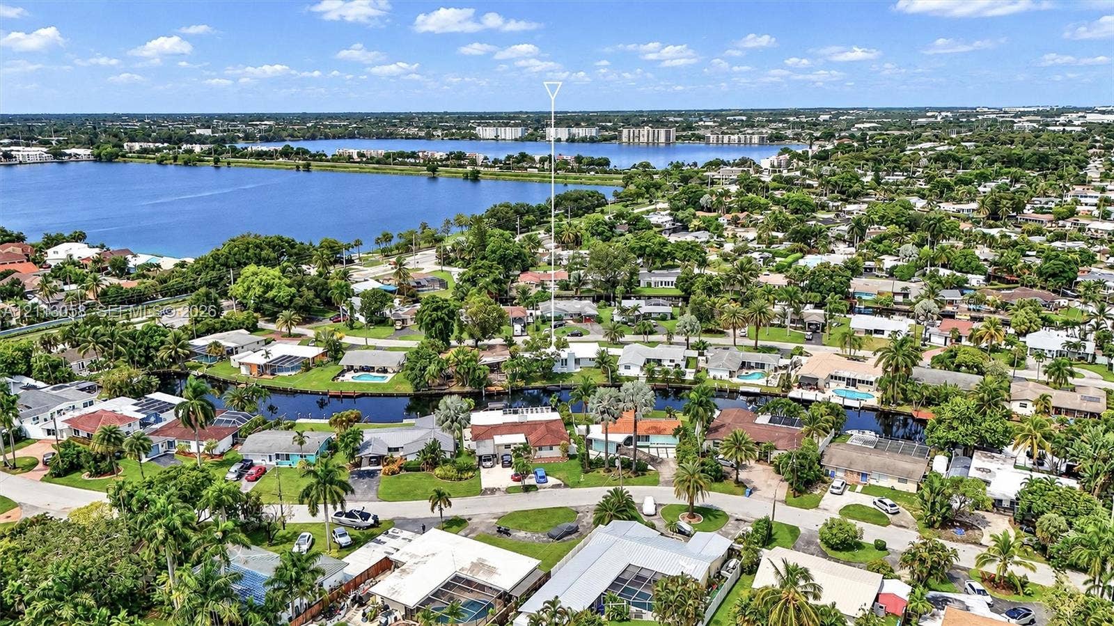 1980 NW 33rd Court, Oakland Park, FL 33309 Aerial perspective featuring waterfront placement along a canal with mature landscaping and proximity to a large inland lake