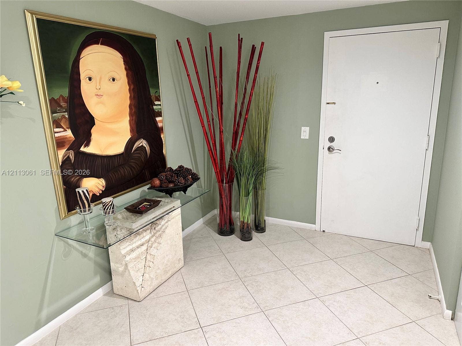 Entryway featuring light-colored diagonal floor tile and a solid-panel door