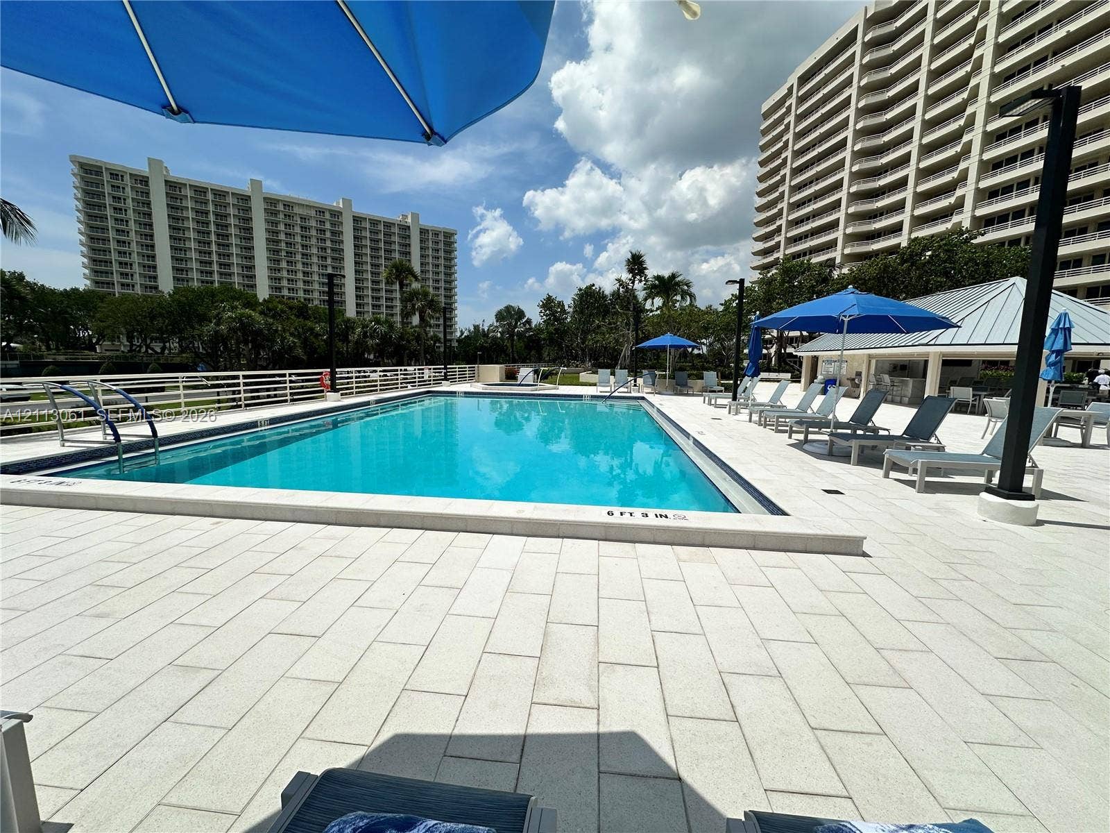 Swimming pool with tiled decking and metal perimeter fencing