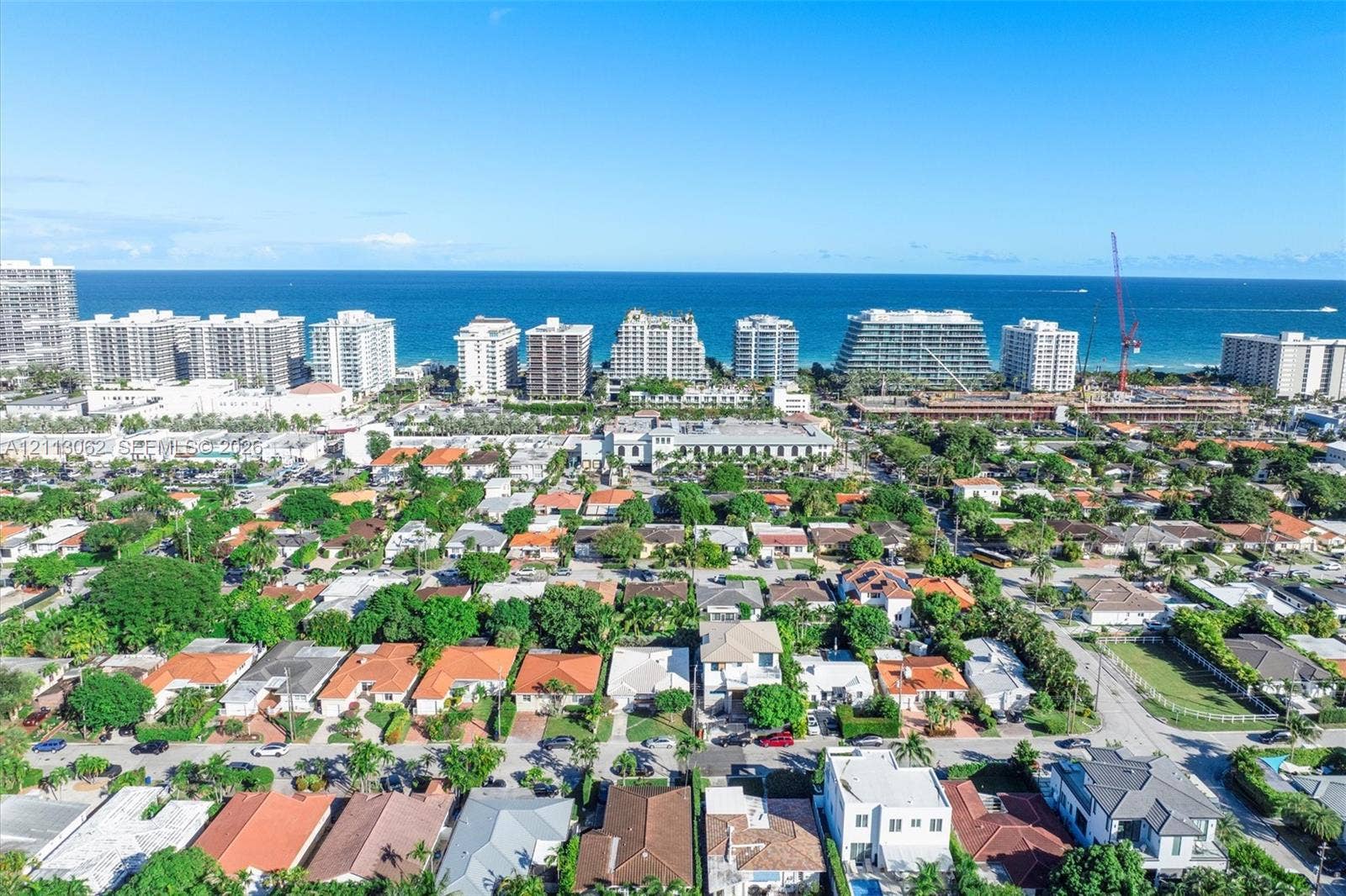 Aerial perspective featuring a coastal residential landscape, expansive ocean horizon, and diverse architectural structures