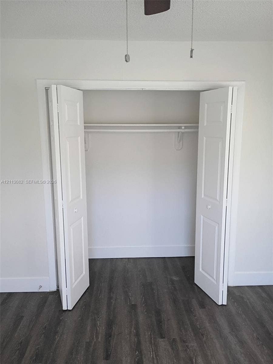 2222 Fillmore Street, #105, Hollywood, Hollywood, FL 33020 Storage closet featuring dual bifold doors and an integrated shelving rod, complemented by wood-finish flooring