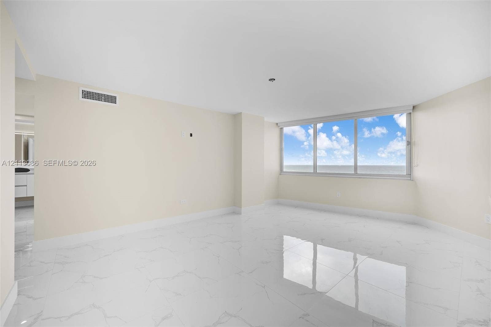 7135 Collins Avenue, #1632, Miami Beach, FL 33141 Bright interior space featuring polished stone-finish flooring, floor-to-ceiling windows, and neutral wall tones
