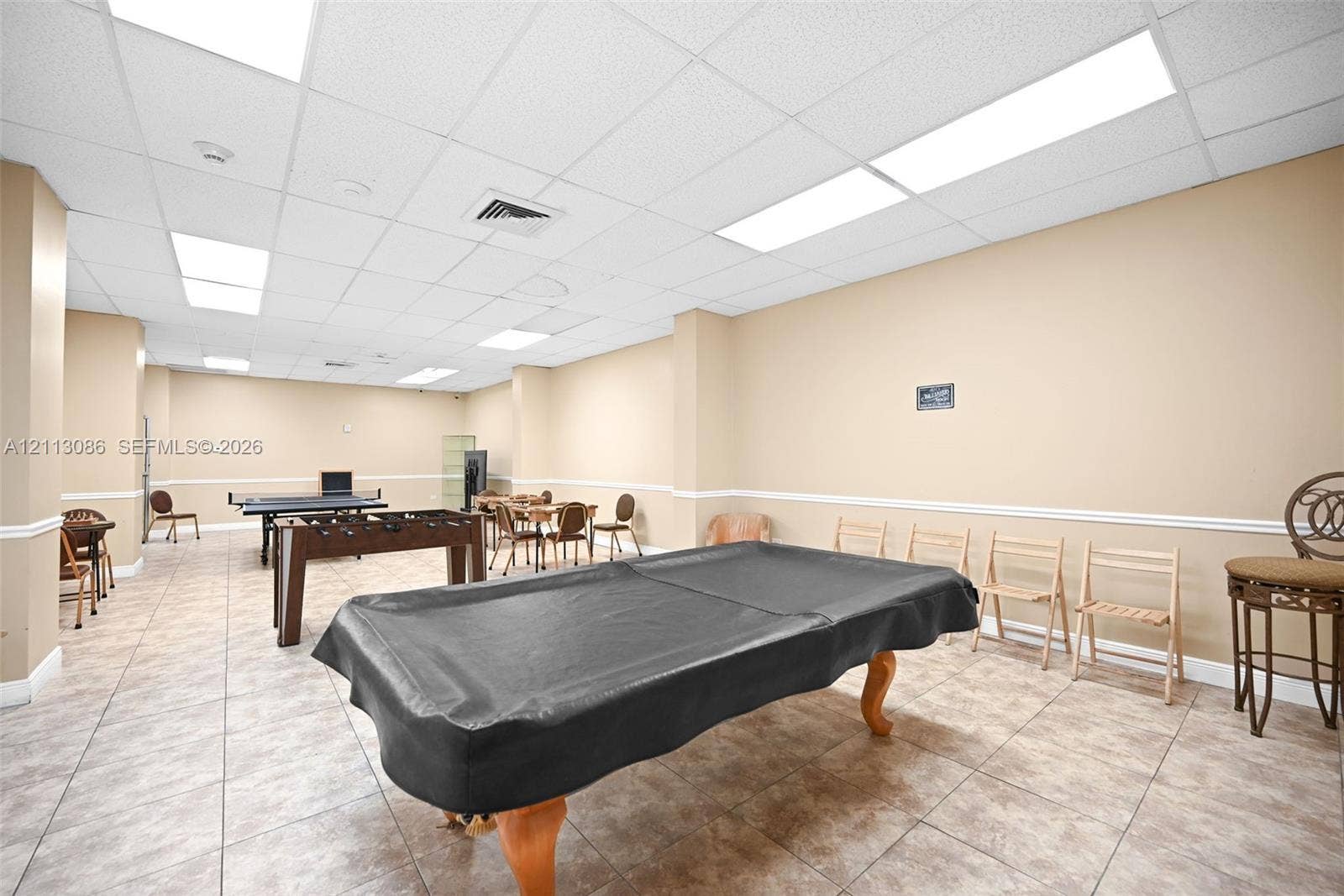 7135 Collins Avenue, #1632, Miami Beach, FL 33141 Large multipurpose room featuring neutral wall paint, tile flooring, recessed drop-ceiling panels, and integrated linear lighting