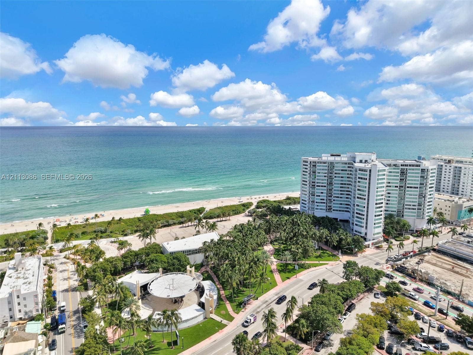 7135 Collins Avenue, #1632, Miami Beach, FL 33141 High-altitude coastal setting featuring a sandy shoreline, turquoise waters, integrated park space with mature palm trees, and an open-air pavilion